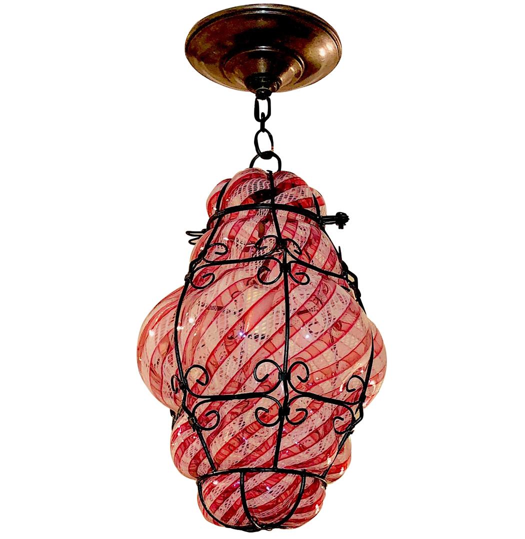 A 1930s Venetian glass lantern, cranberry and clear glass with iron frame.

Measurements:
Drop 15