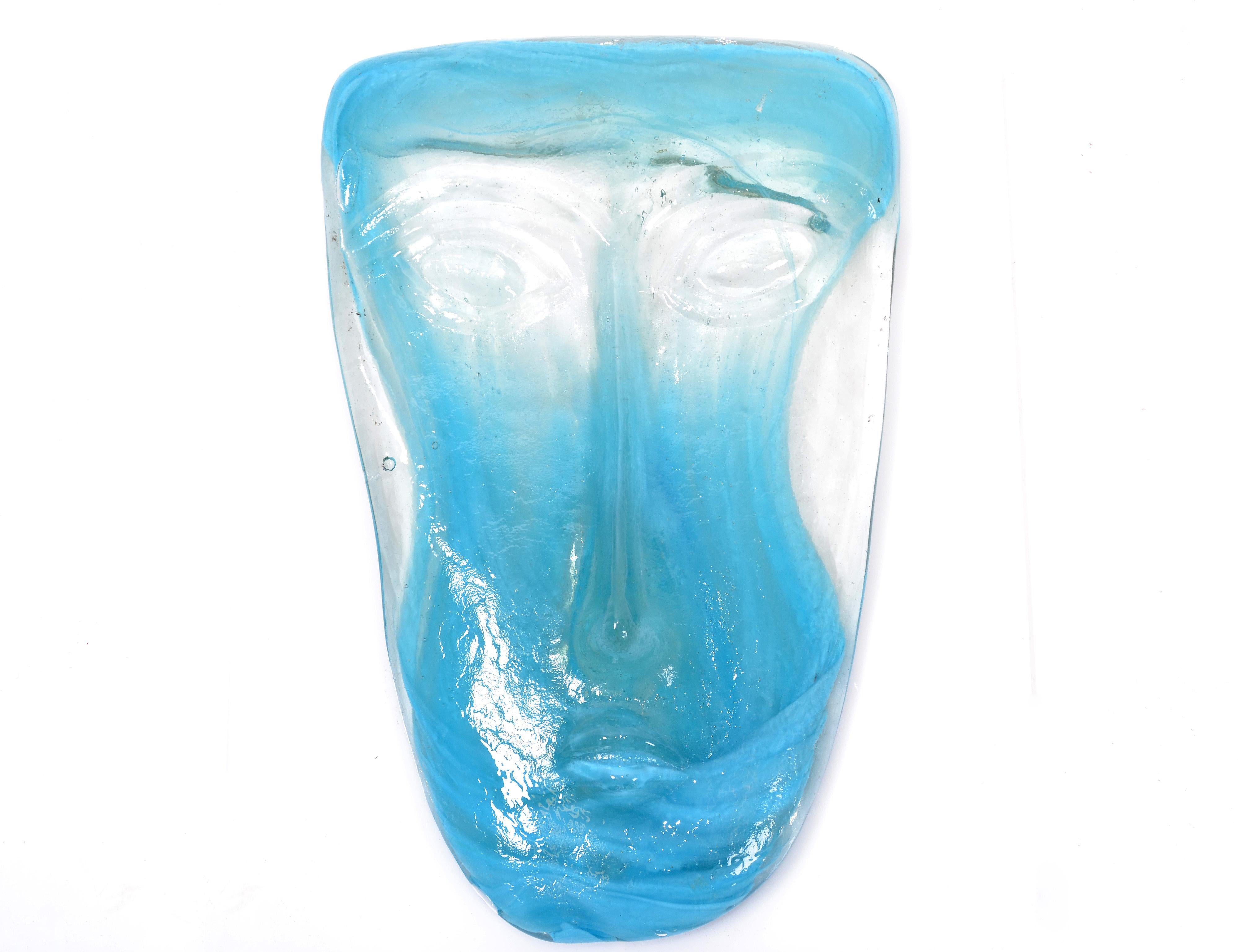 Folk Art blown turquoise and clear Art Glass face masks with wall mounted candleholder made in México.
The glass face mask sits firmly into the frame which is mounted to the wall.
A candle placed behind the mask creates a cozy atmosphere.