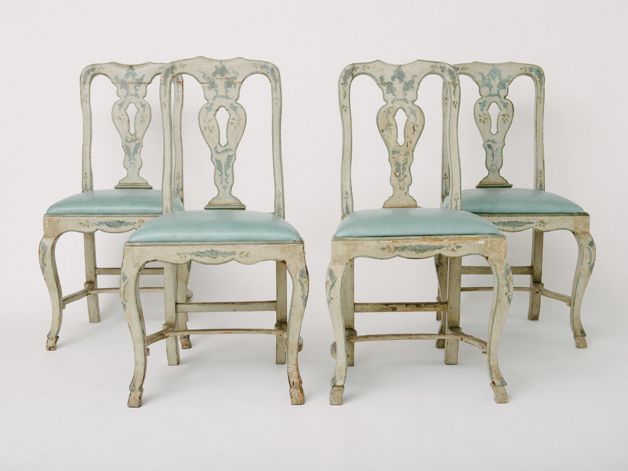 18th century blue-gray painted Venetian side chairs with leather seats. Chairs have a heraldic style cross maker's mark engraved on backs of chairs. Features hand carved stretchers and pied-de-biche hooves, seat covered in a sky blue leather. Uneven