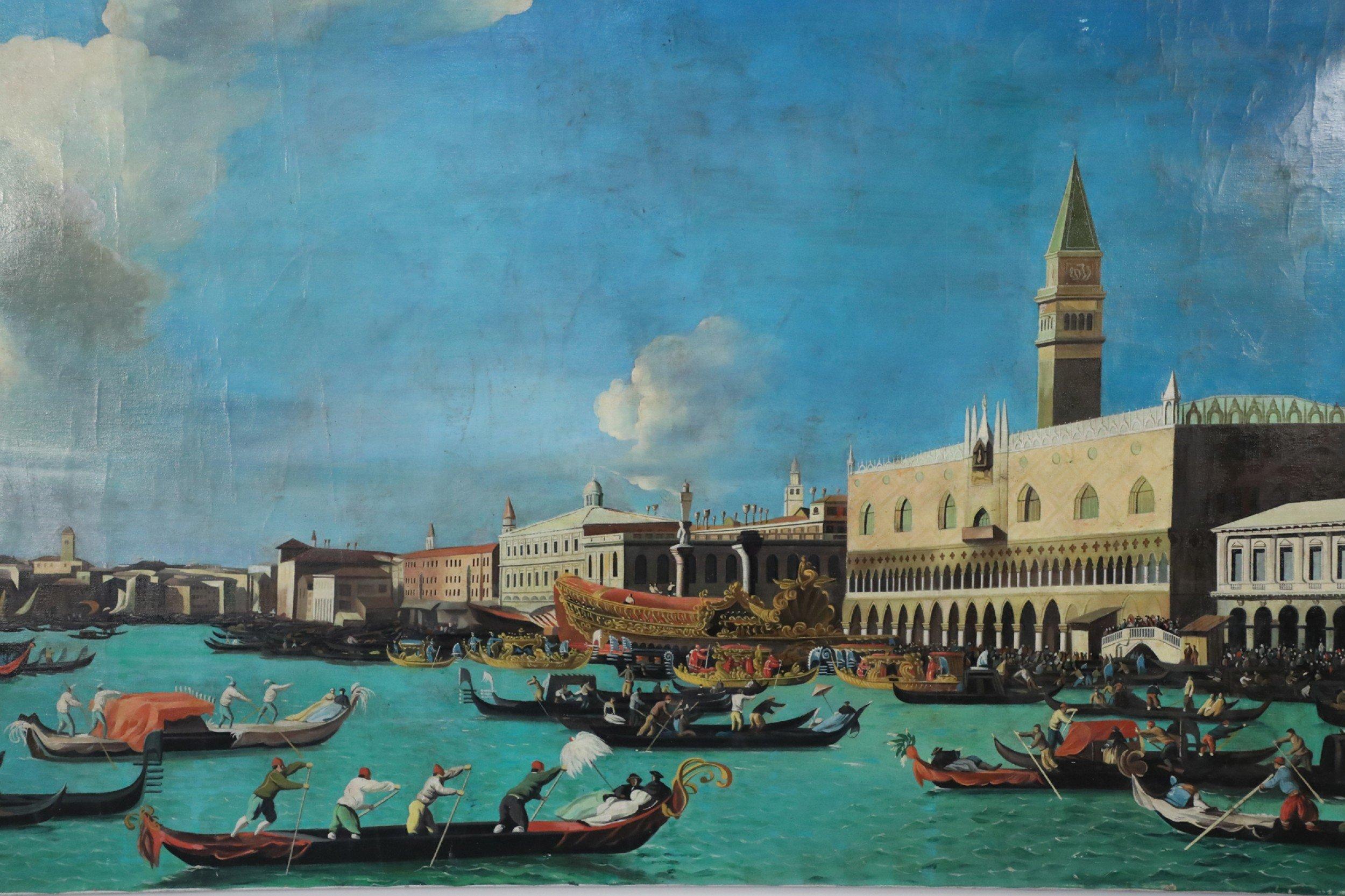 Pintura al óleo sobre lienzo, sin enmarcar, de estilo Grand Tour (siglo XX), de un brillante canal acuático atestado de góndolas al paso frente al Palacio Ducal, con el Campanile de San Marcos justo detrás y las cúpulas de la Punta de la Dogana