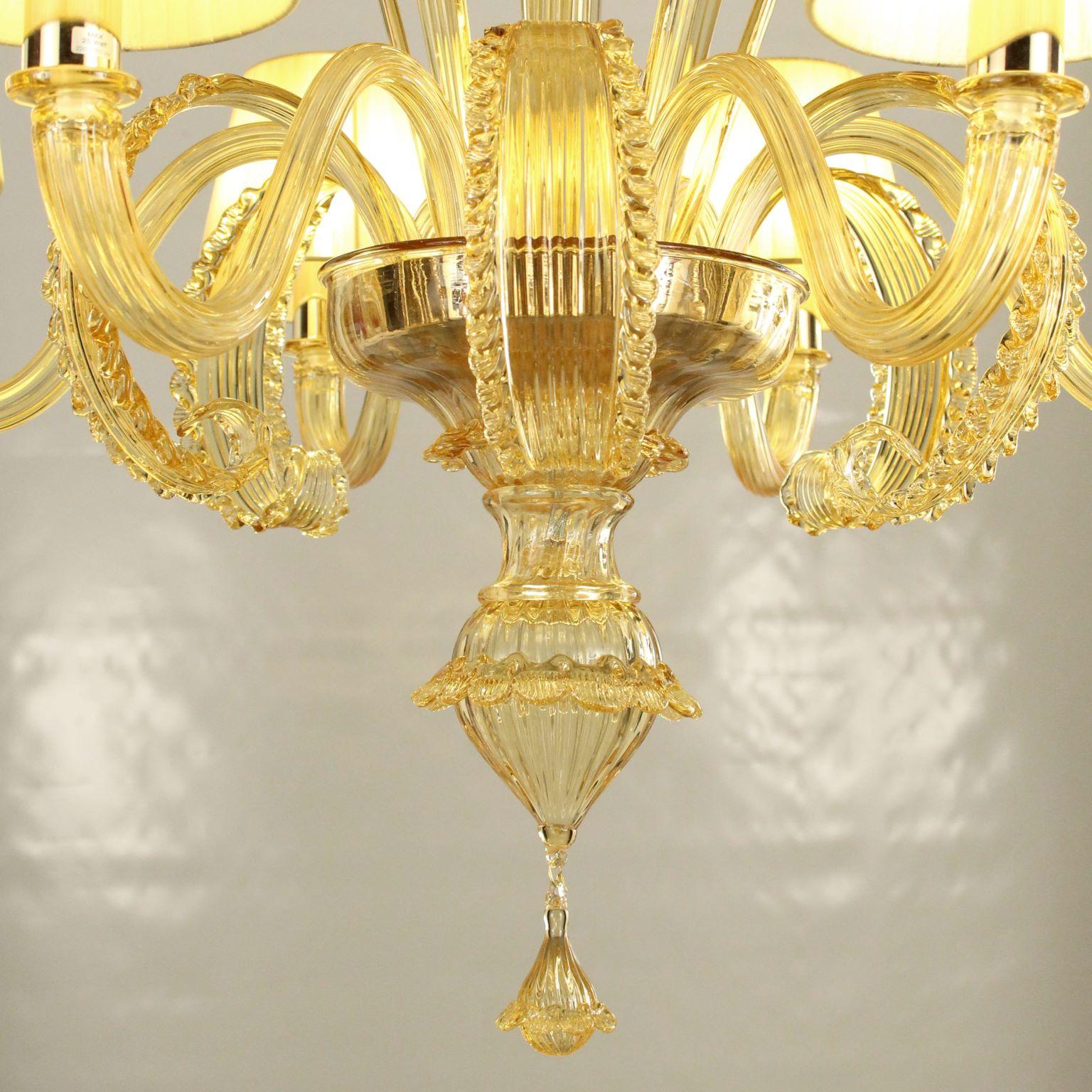 Venetian chandelier with 6 arms in amber Murano glass and amber details with light amber cotton lampshades.
This is a classic Murano glass chandelier, as it is in the collective imagination. As many other chandeliers in our collections, this is