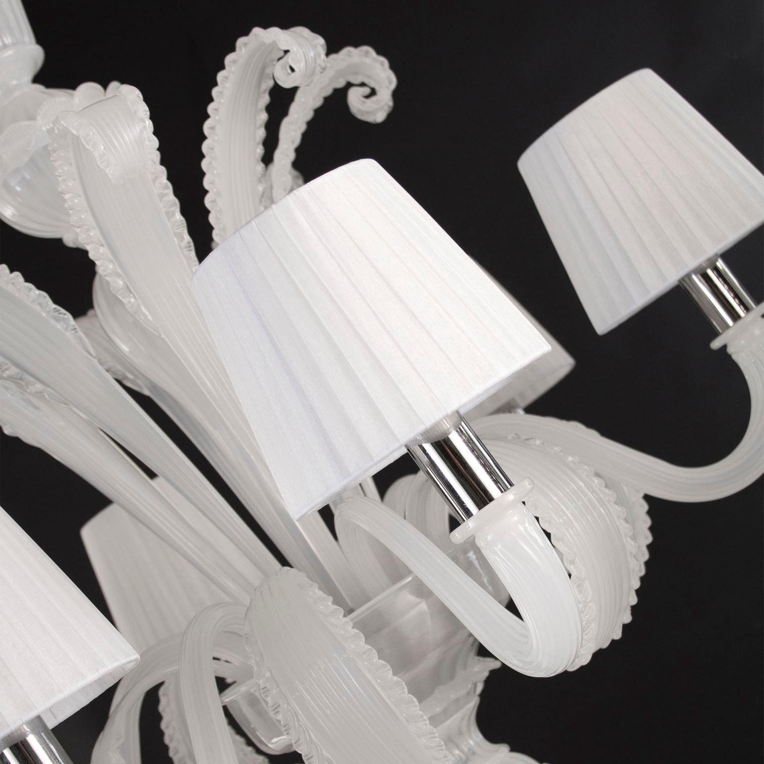 Venetian chandelier with 6 arms in white silk Murano glass with white cotton lampshades.
This is a classic Murano glass chandelier, as it is in the collective imagination. As many other chandeliers in our collections, this is designed with attention