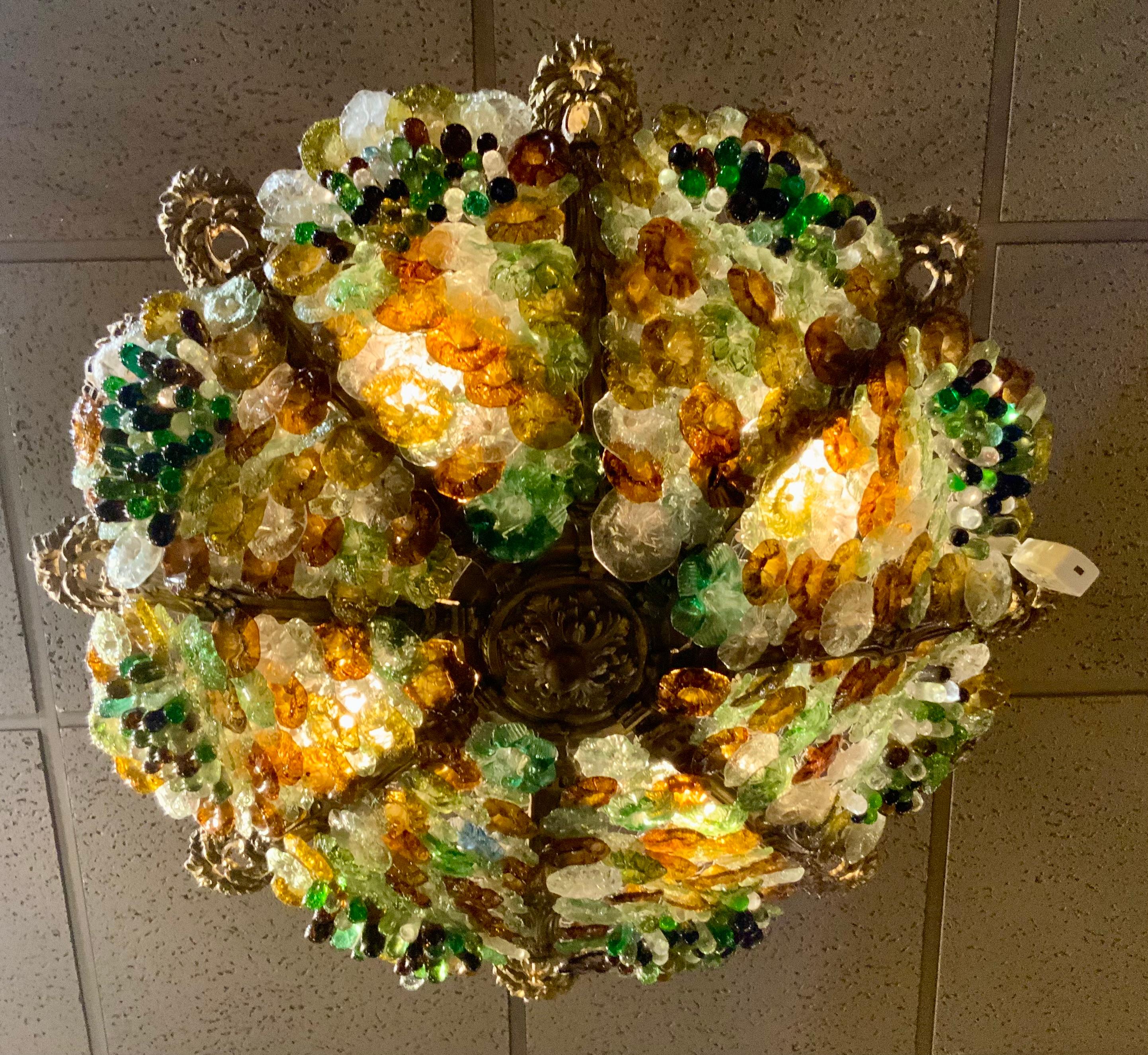 Les couleurs du verre sont vibrantes dans les tons de jaune 
Vert et bronze.  Les grappes de raisin sont exposées 
En groupes sur ce luminaire. Trois lumières à l'intérieur
Illuminez un éclat lumineux.  Il est suspendu à huit chaînes
De forme
