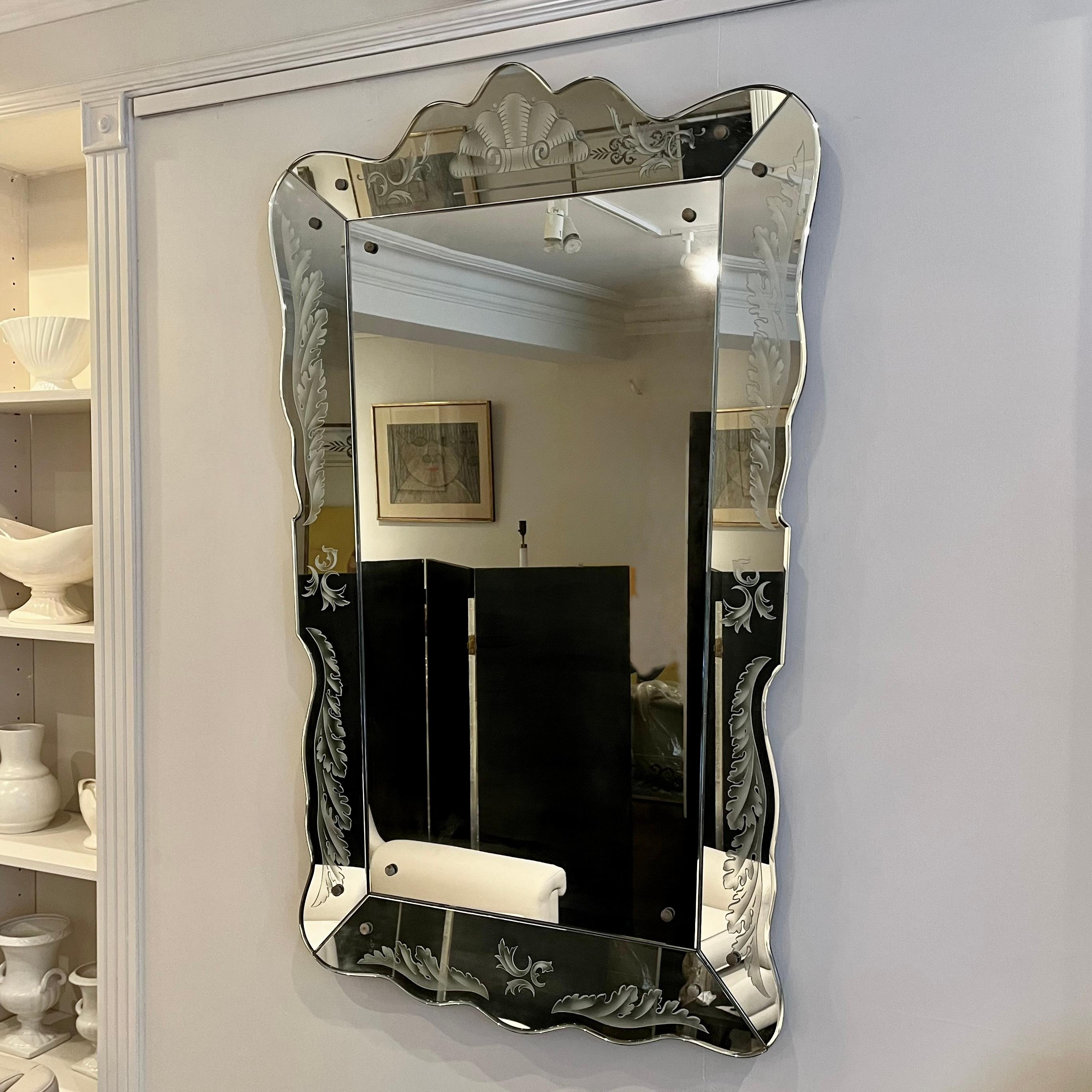 Exceptionnel miroir en cristal vénitien de Pietro Chiesa pour Fontana Arte vers 1940. Décorée d'une feuille d'acanthe gravée à la main et d'une forme de coquille enroulée sur le dessus. 

