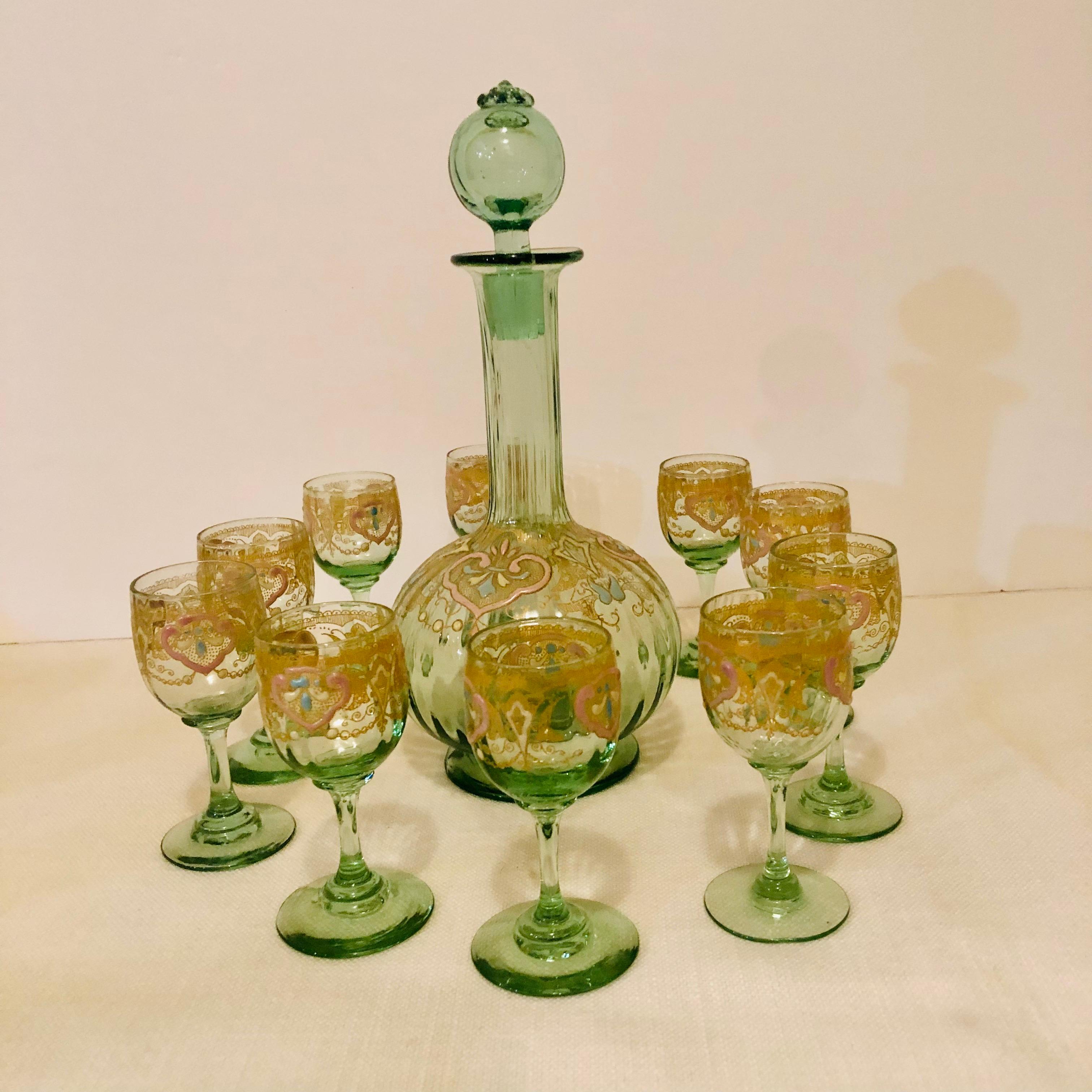 This is a beautiful set of Venetian green glass with a decanter and ten cordial glasses. Each piece is decorated with colorful enamel accents in pink, blue and cream colors, as well as gilt embellishments on the green glass ground as you can see in