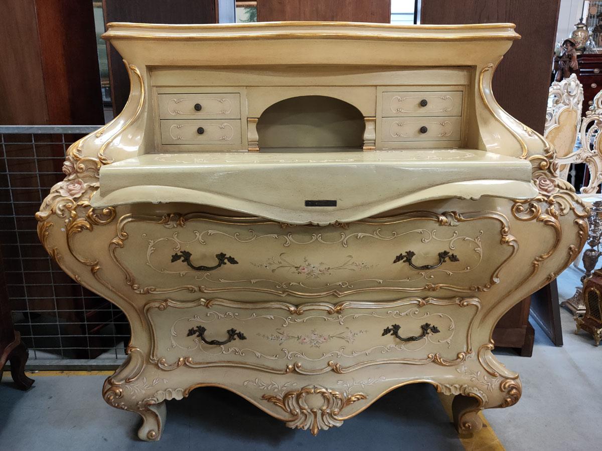 A prestigious piece of furniture for the connoisseur of the subject.
Unusual, most likely made to order, neo-rococo Venetian desk, with ecru polychrome (slightly olive-colored), beautiful gilding and hand-made floral paintings, characteristic of