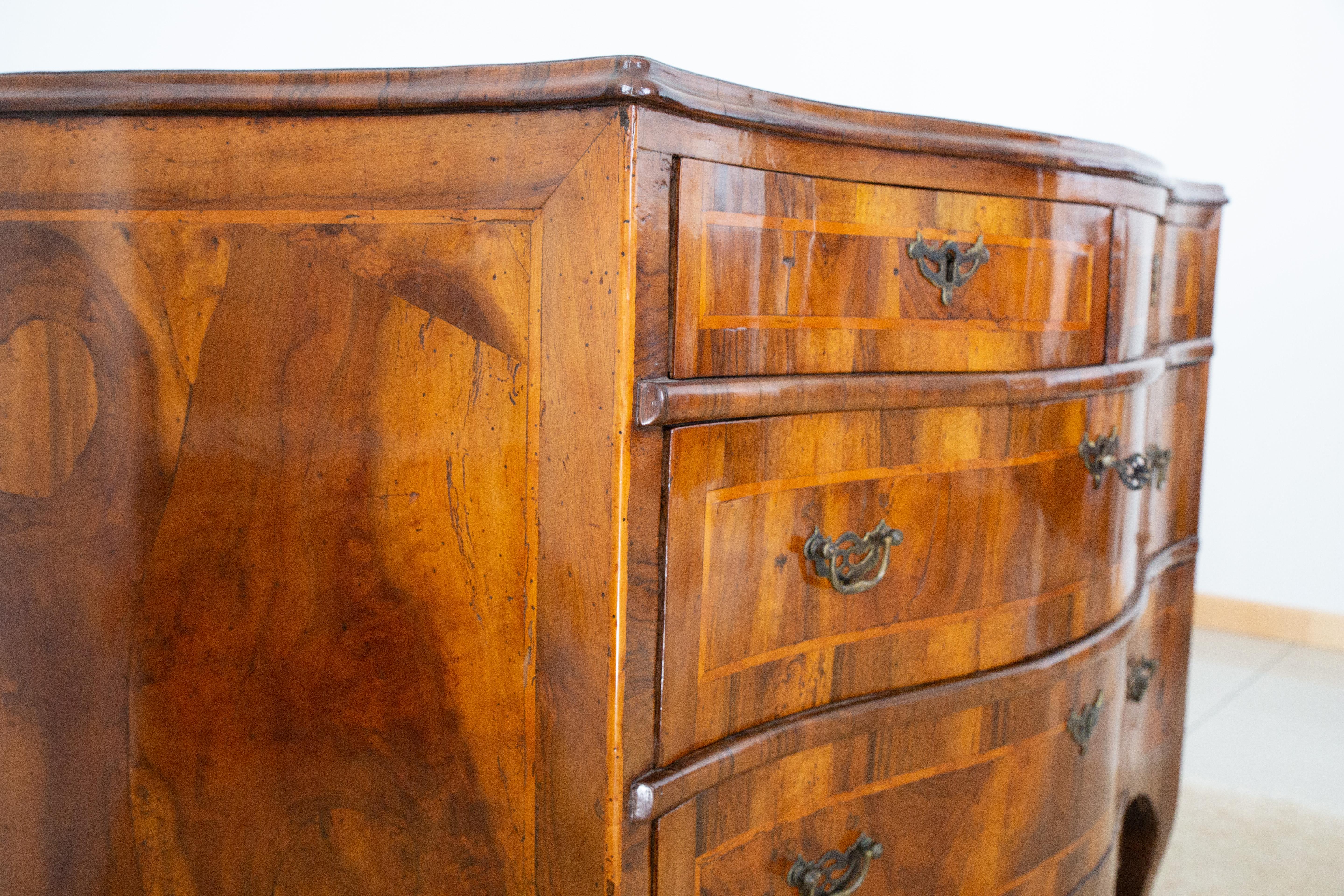 Venetian chest of drawers with a contoured shape both on the front and on the sides, veneered in walnut and walnut root on both the front and on the sides and threaded in maple wood.

Period: third quarter of the 18th century

Origin:
