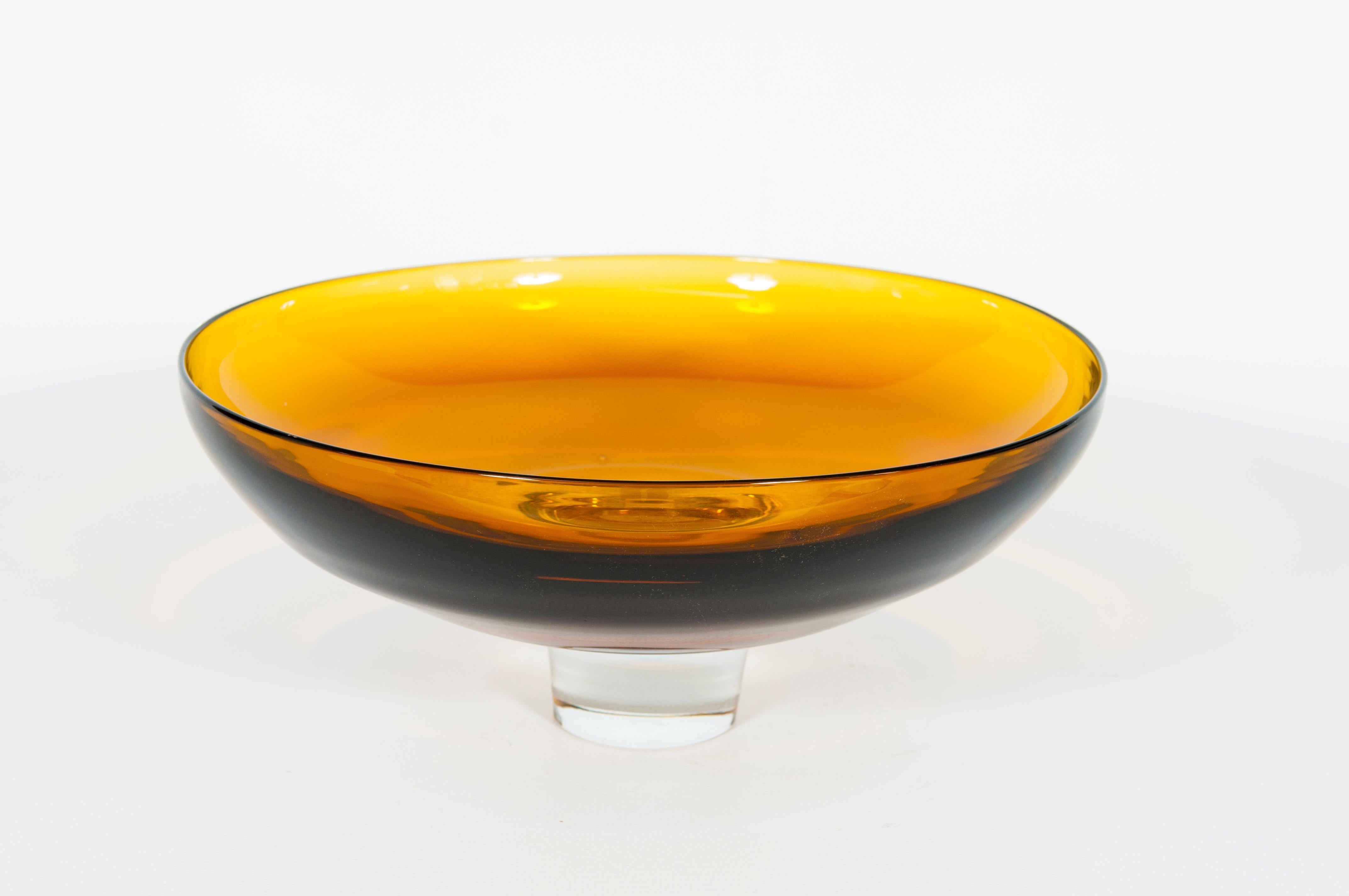 Venetian Footed Bowl in Amber Blown Murano Glass Italy 21st Century.
This bright footed bowl is a completely handcrafted work of art dating from the 2000s. Created in Venice, Italy, following the ancient technique of the Murano blown glass, it