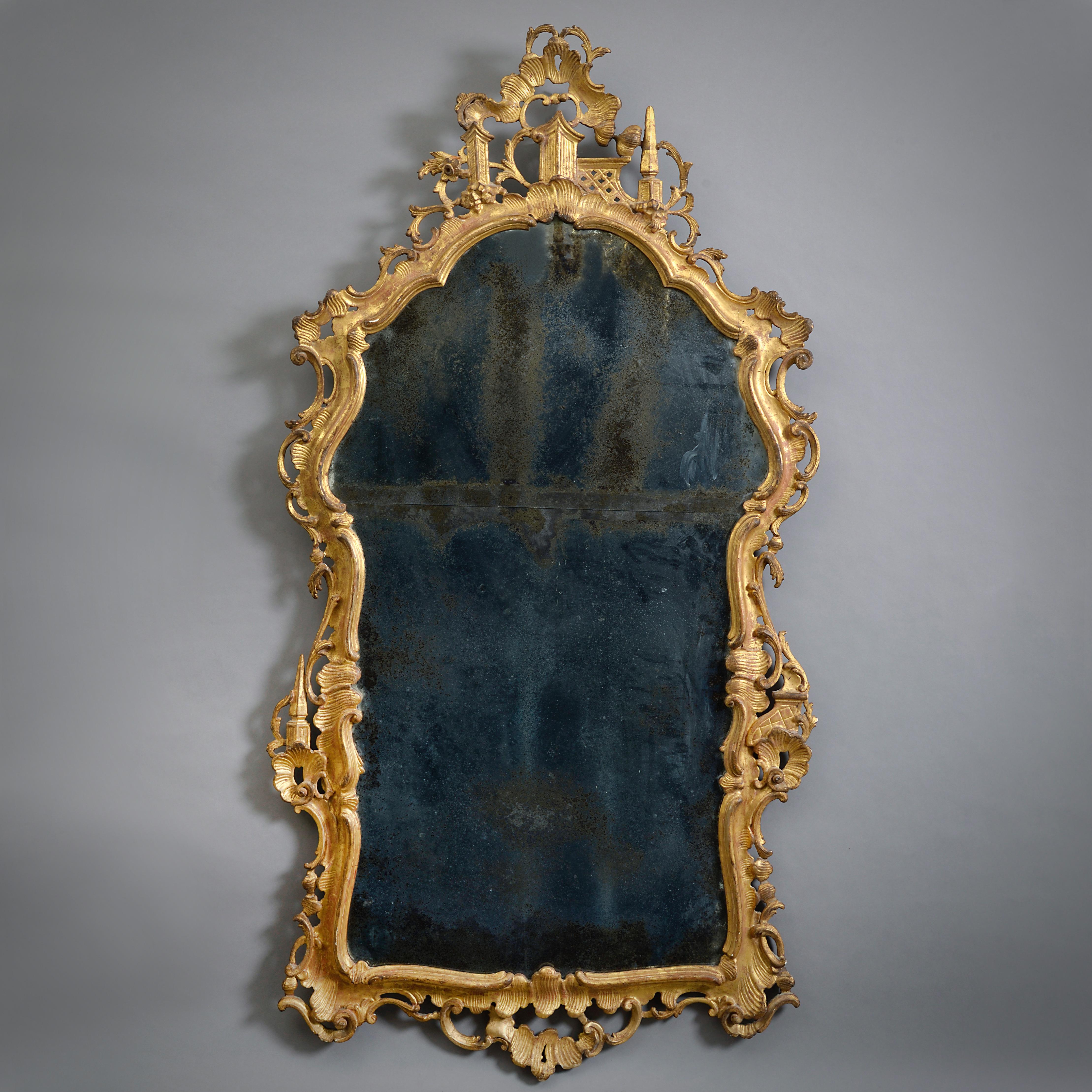A VENETIAN GILTWOOD MIRROR, CIRCA 1750.

With original shaped and divided plates. The frame carved with scrolls, rocailles, and obelisks.