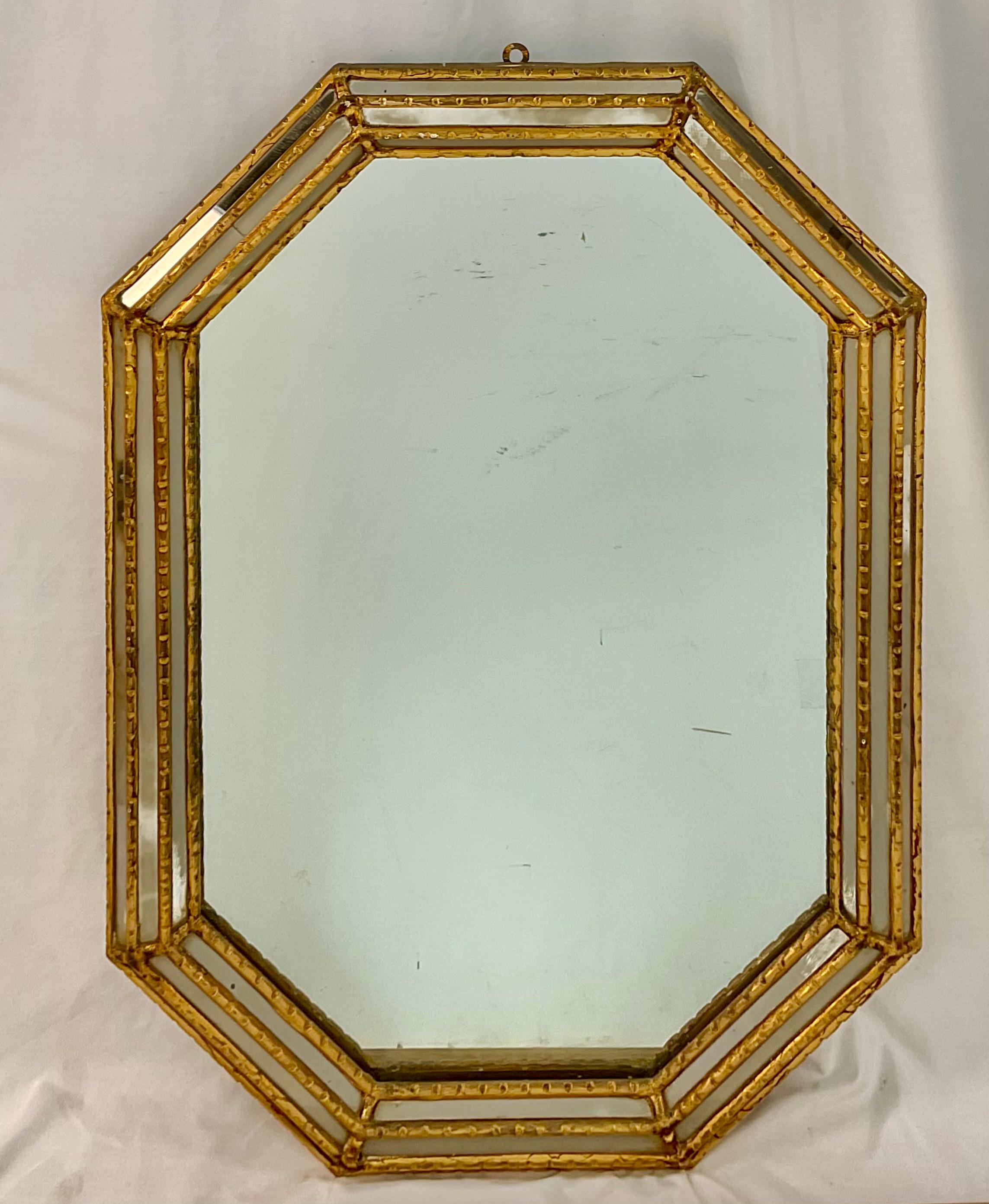 Miroir mural hexagonal vénitien du début du 20e siècle. Le cadre est en bois doré avec des inserts étroits en miroir. Estampille 