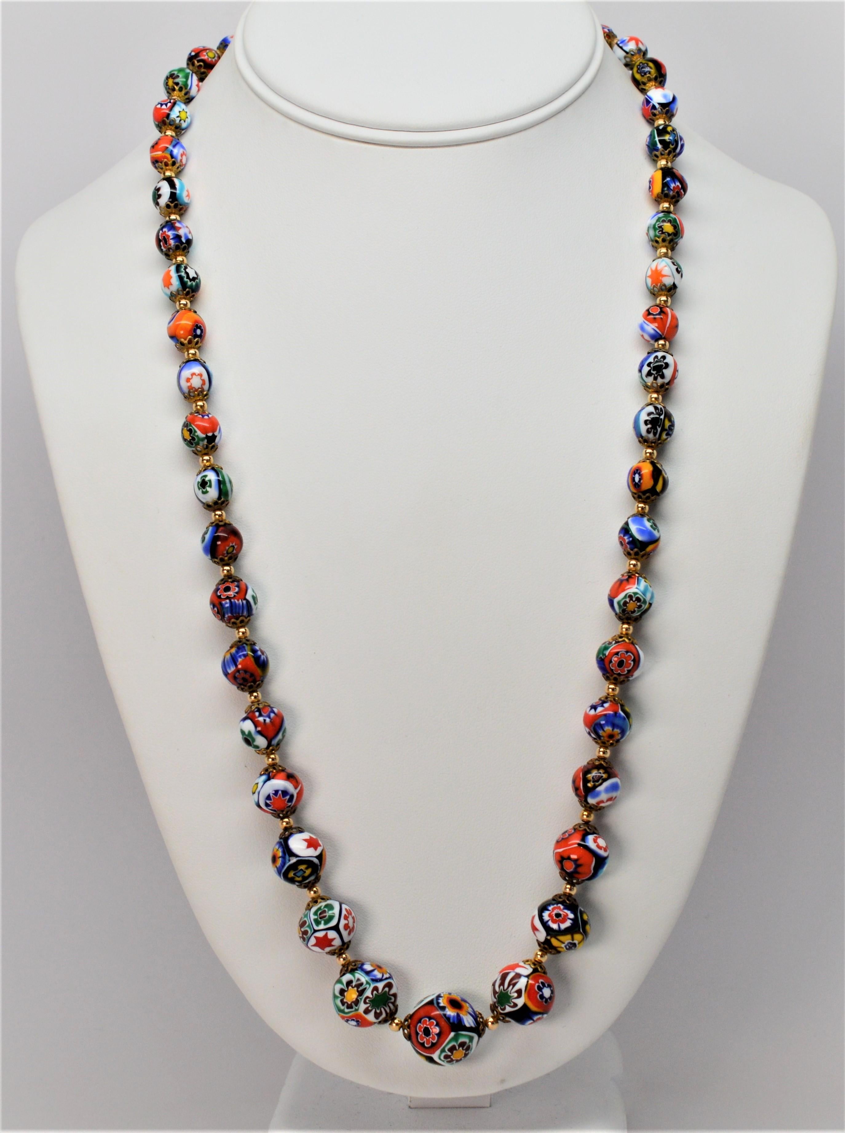 Bright and artful, this mid-century twenty four inch necklace is hand-strung with beautiful and distinctive Venetian glass beads graduating in size from 7.5mm to 15mm. A mosaic of color, each bead is of distinctive design and complimented with 14