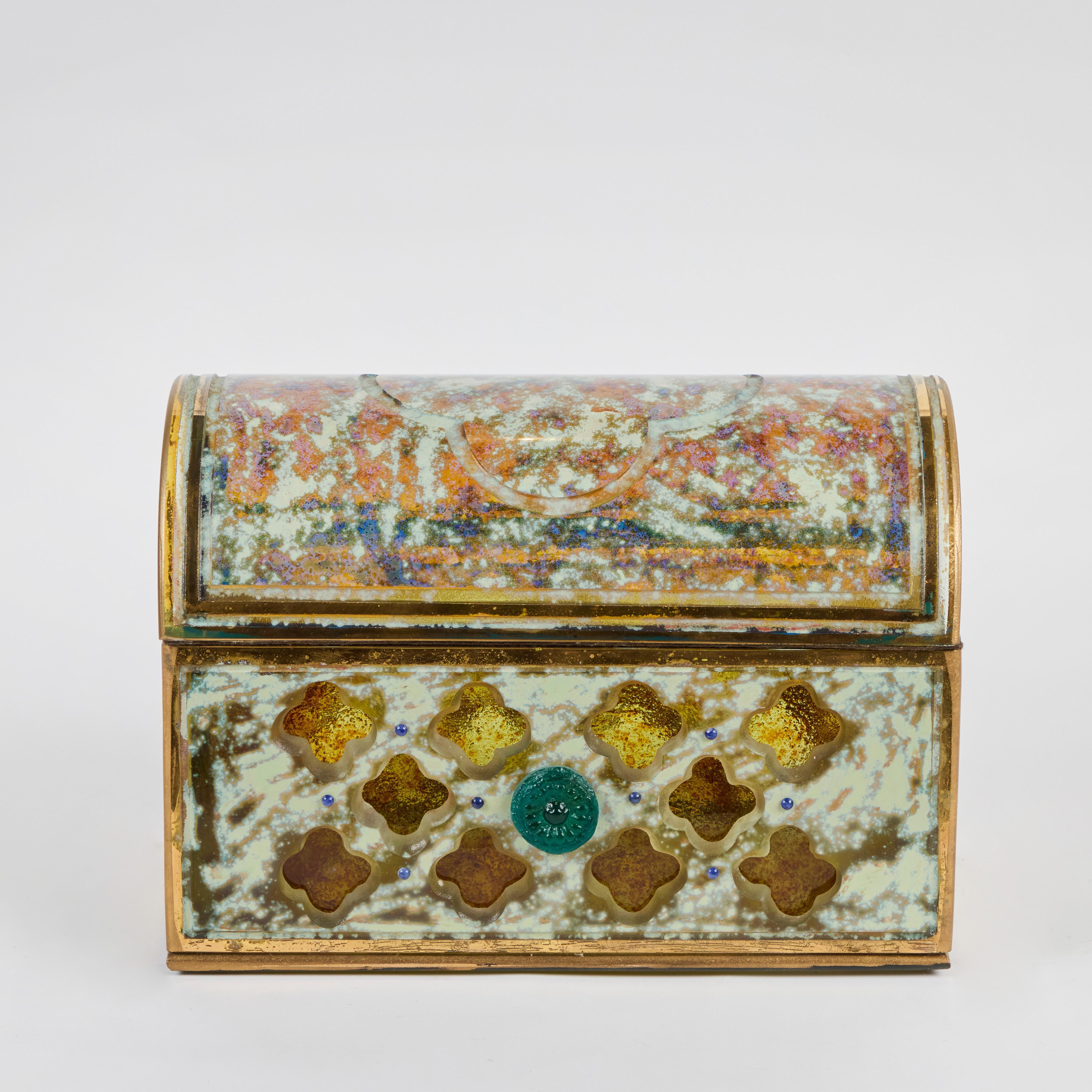 Una inusual arqueta de cristal veneciano con detalles dorados y lapislázuli, con un medallón central de cristal.