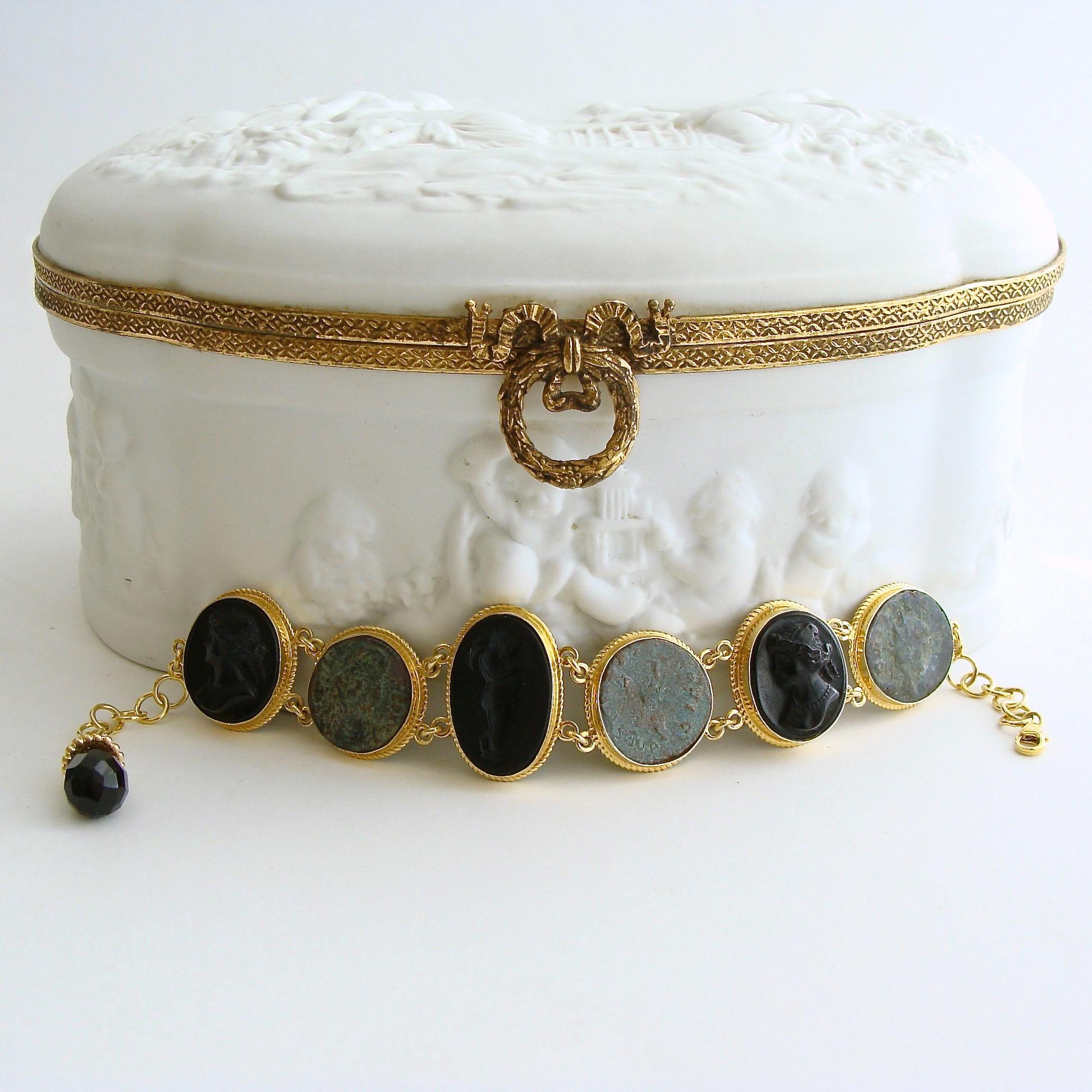Distinctive black Venetian glass cameos/intaglios alternate with graphite gray ancient Roman coins to create this classic bracelet.  Each of the intaglios and coins sits in bezeled mountings accented with a twisted border made of gold vermeil.  The