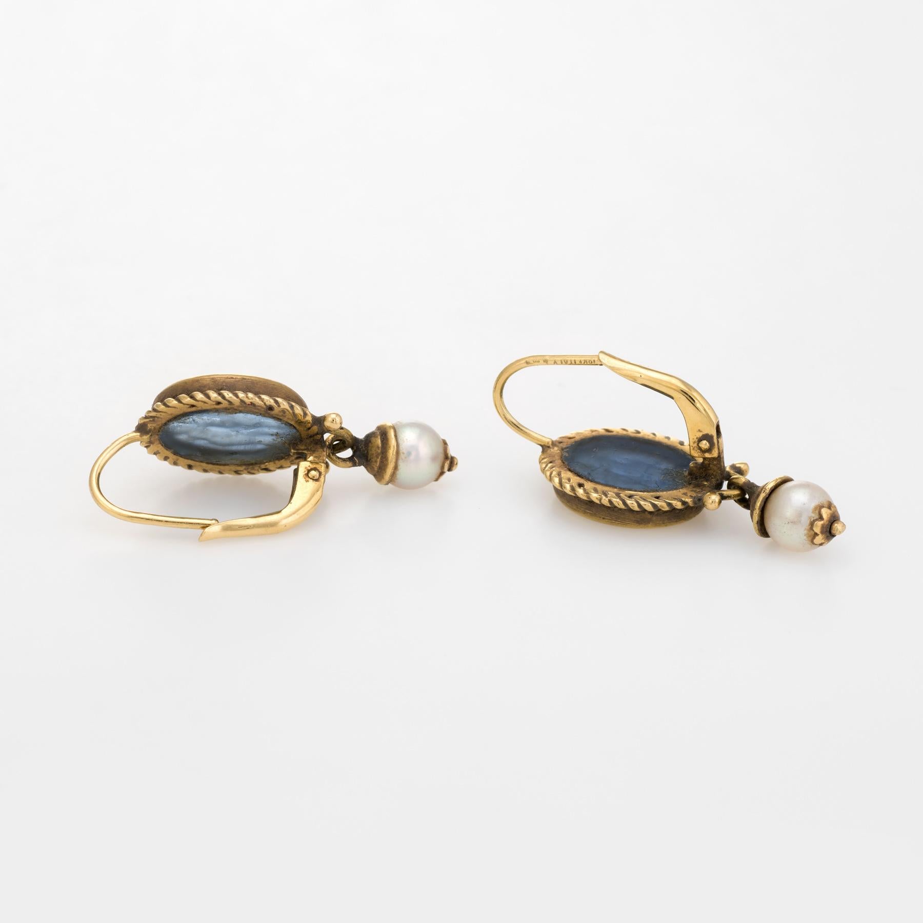 Finely detailed pair of vintage earrings, crafted in 18 karat yellow gold.

Cherubs are etched into venetian glass and set into ornate oval shaped mounts. Two 5.5mm cultured pearls adorn the lower drops. 

The earrings are in excellent