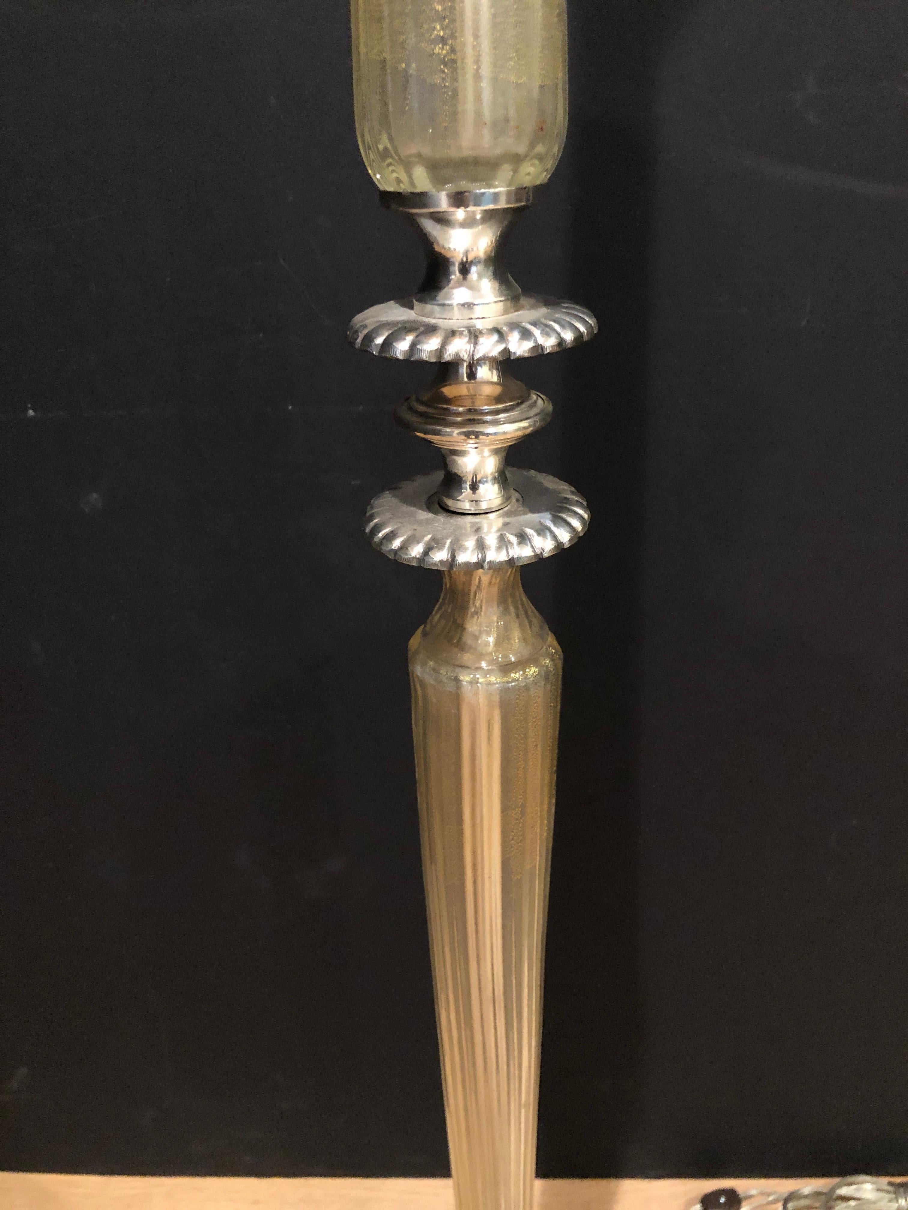 Murano glass midcentury torchiere floor lamp with silvered bronze legs and decorative elements. Hand blown fluted glass columns with gold flecks. Original torchere shade from spun aluminum.
