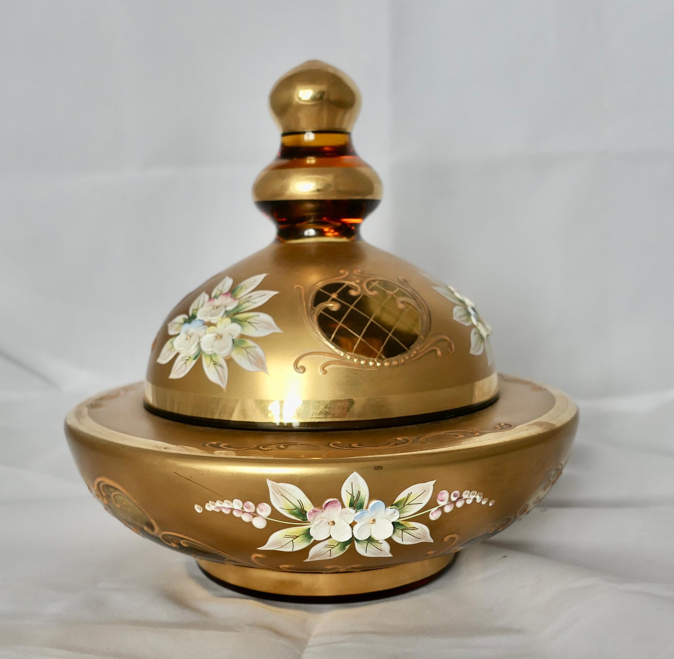 Venetian Gold Enamel Murano Glass BonBonier with Lid

A lovely mid century piece luxurious Gold on Amber Glass, with tiny flowers in relief 
The Dish is 7” in diameter and 7” high and in good condition
FB148