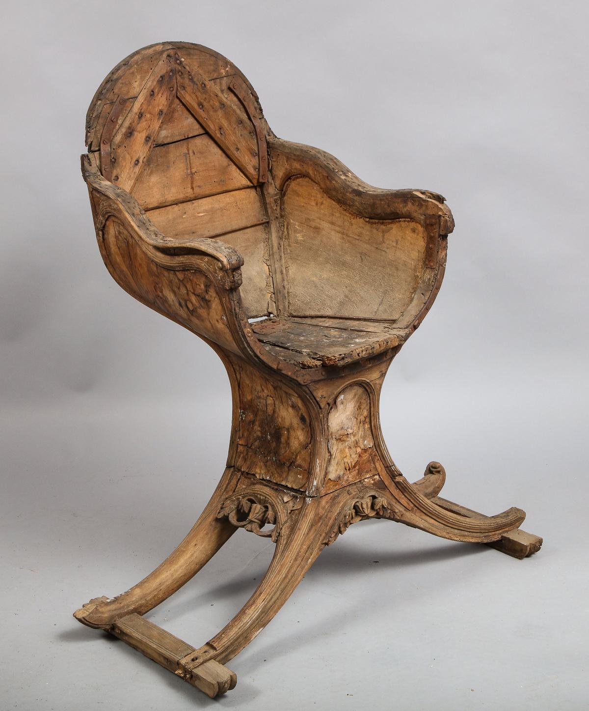 Rare 18th century Venetian gondola chair in perfect state of decay, now lacking upholstery, much loss to burl walnut veneer and carved solid walnut elements, the seat with lift up compartment for valuables, standing on spayed legs mounted to