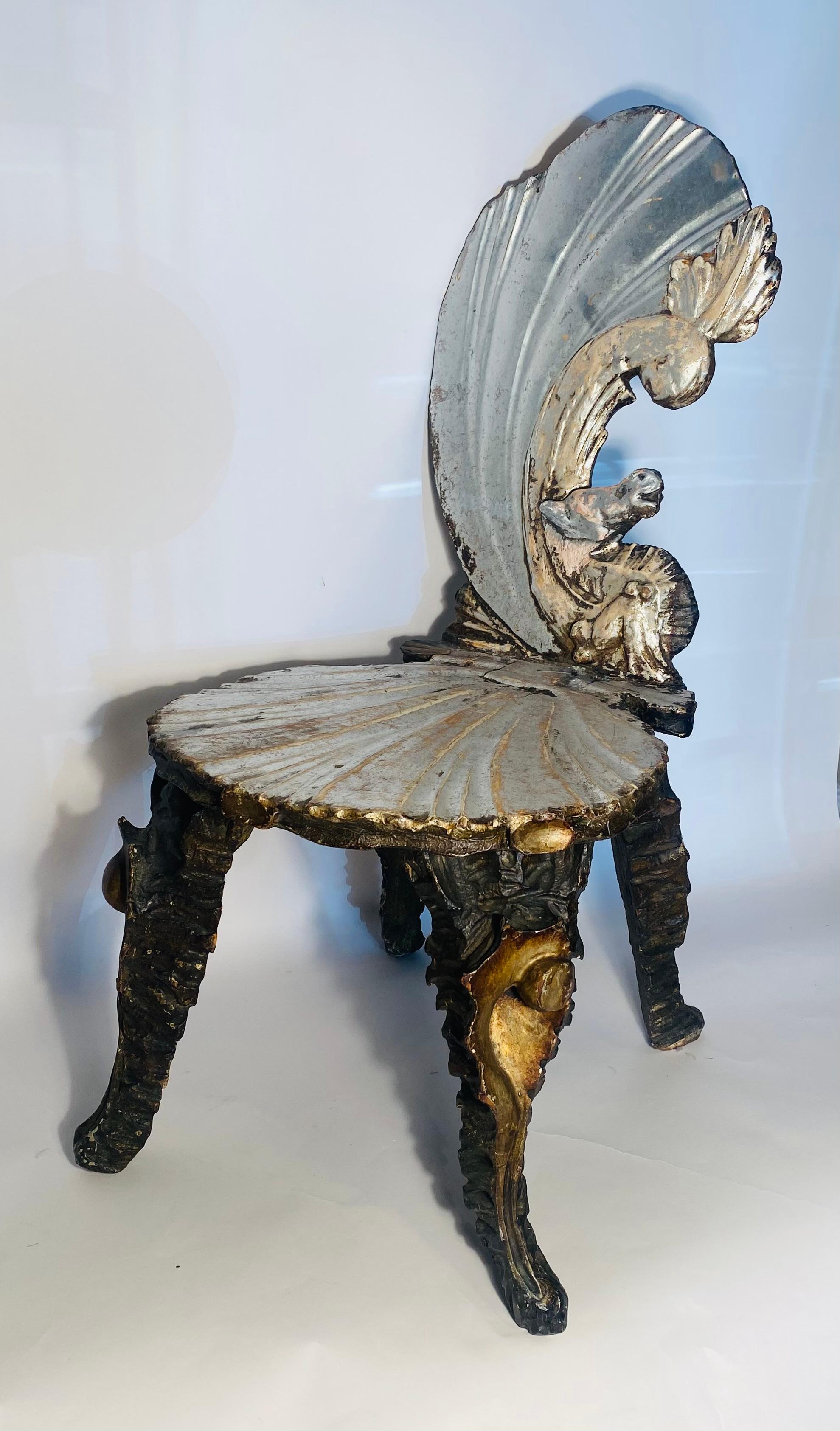 A whimsical fantasy hand carved chair by the great Venetian craftsman of the era. This lovely piece features an unique seahorse carved back and scallop shell seat retaining much of its antique silvered wood. The legs are carved in the shape of