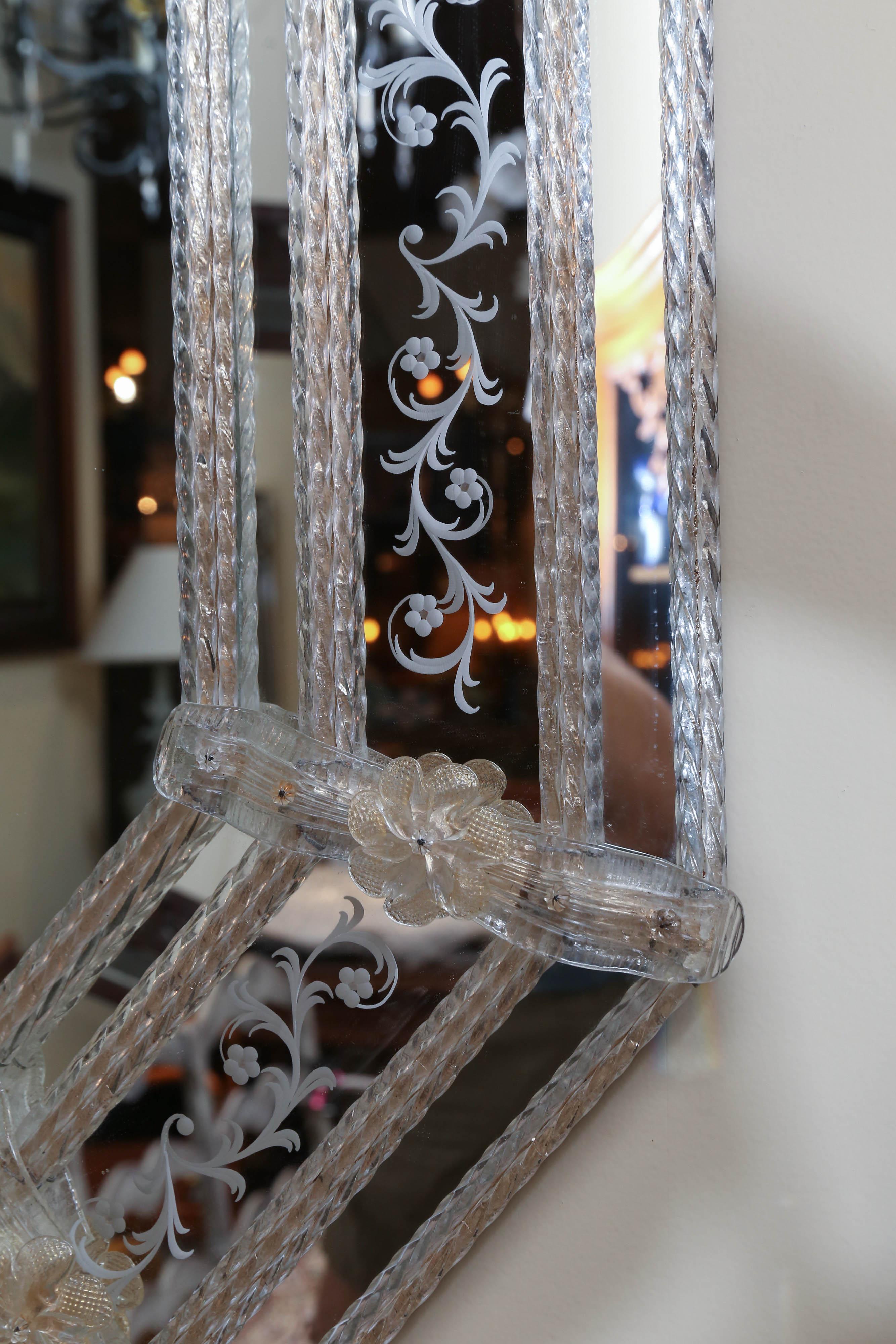 Venetian glass mirror in a lovely shape having floral
and scrolls decorating the edges.
