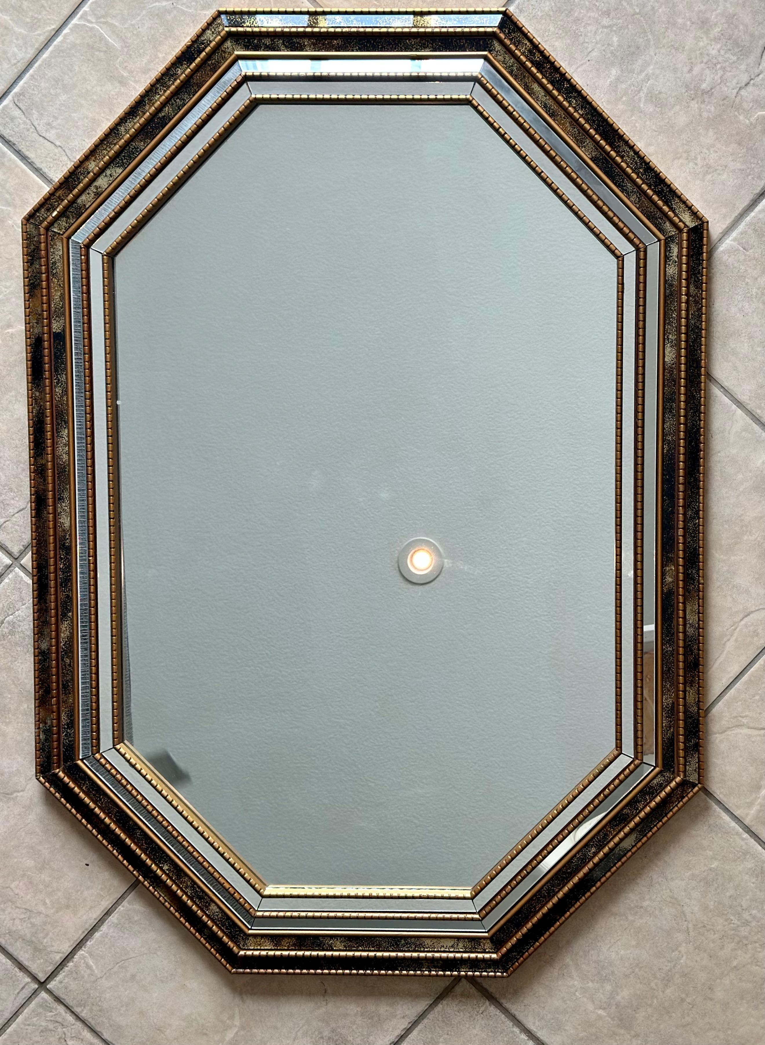 Venetian style 8 sided gilt wood wall mirror, accented with smaller clear and gold vein mirror panels. A wonderfully crafted Hollywood Regency mid-century period wall mirror.
  
