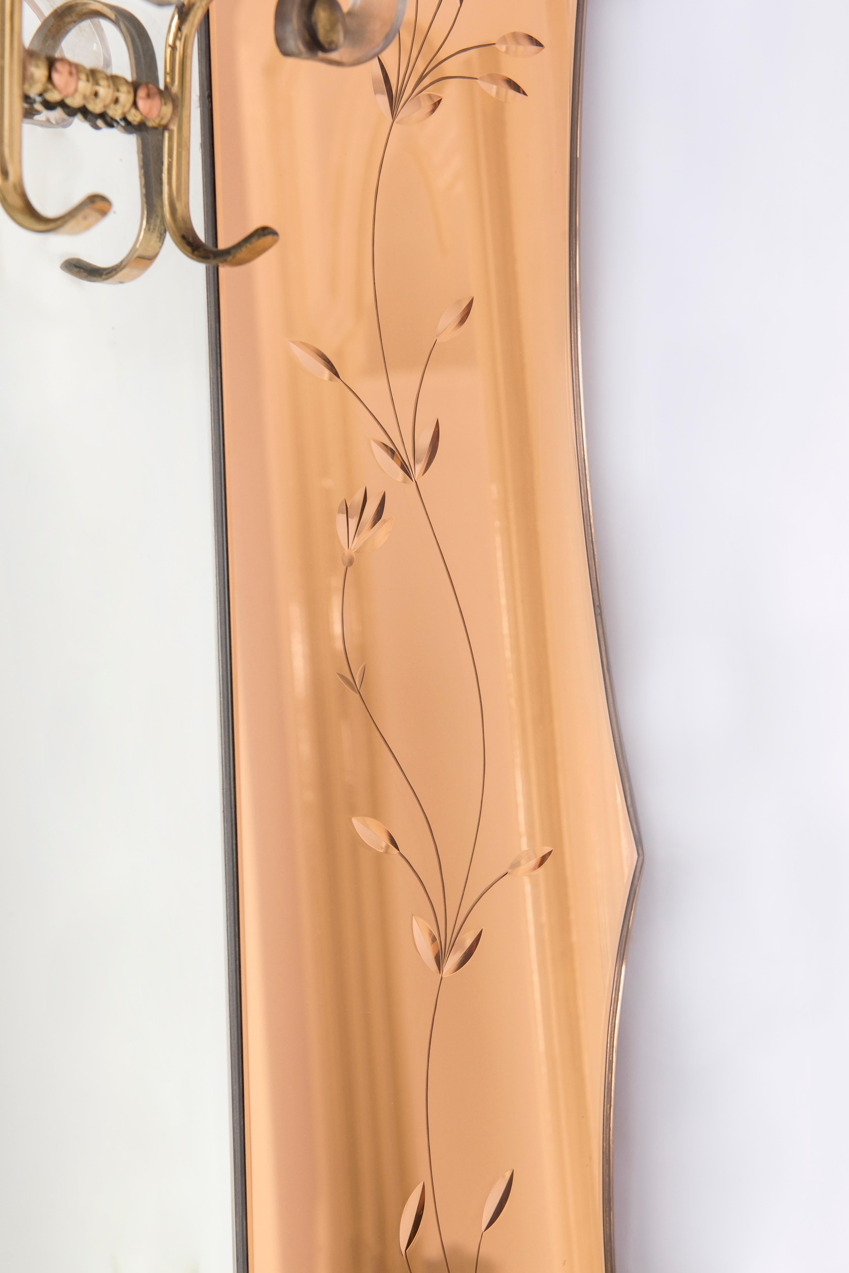 Italian origin Venetian Art Deco wall mirror and coat hanger. Huge full length mirror in the middle surrounded by rose colored edged mirrors. Four coat hangs in brass and glass in the middle and one transparent glass shelf overneath to hold hats.