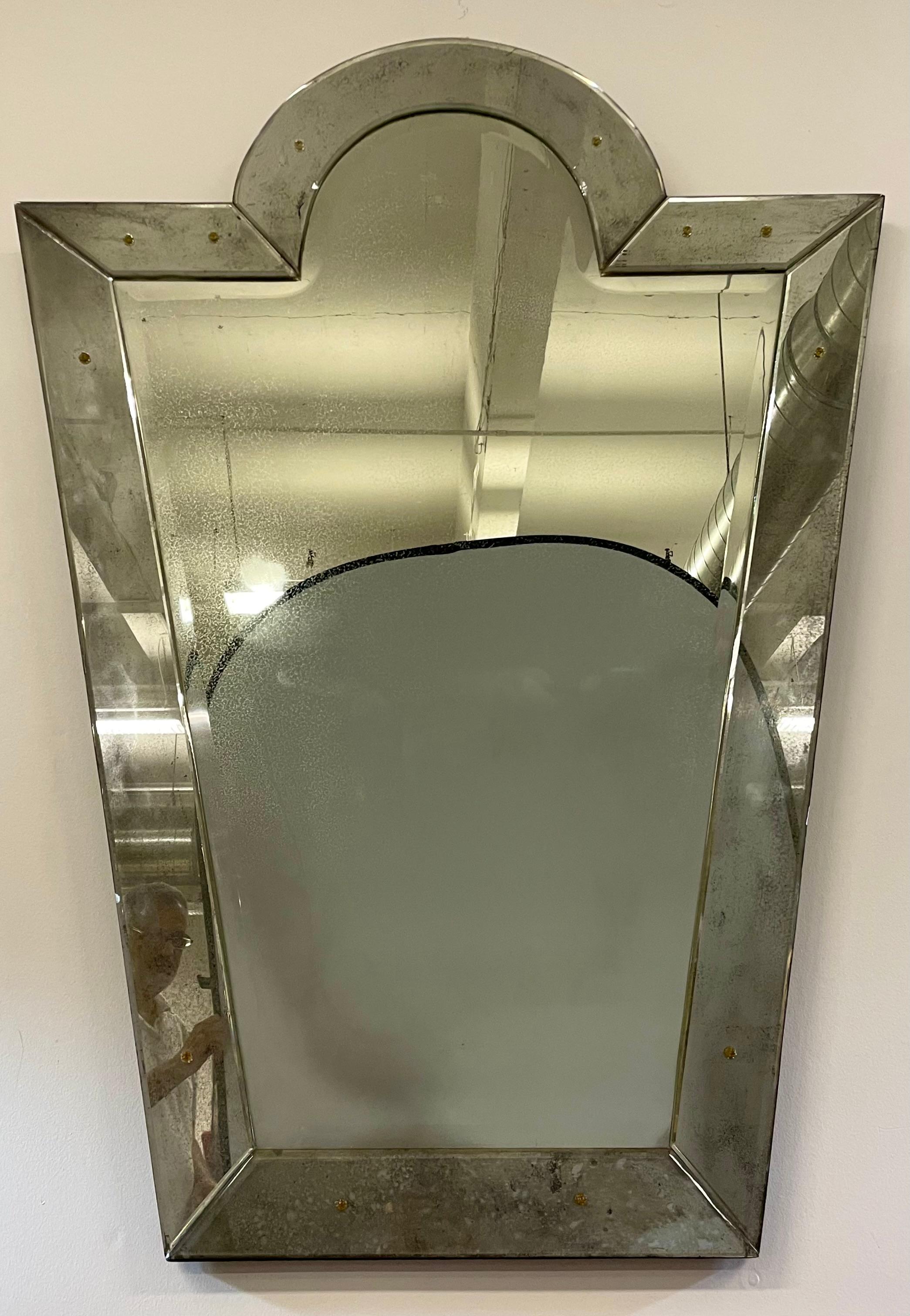 Mid-Century Modern style Venetian key hole shaped mirror. The center beveled panel mirror flanked by six beveled sided mirrored panels. 36' wide tapering down to 20