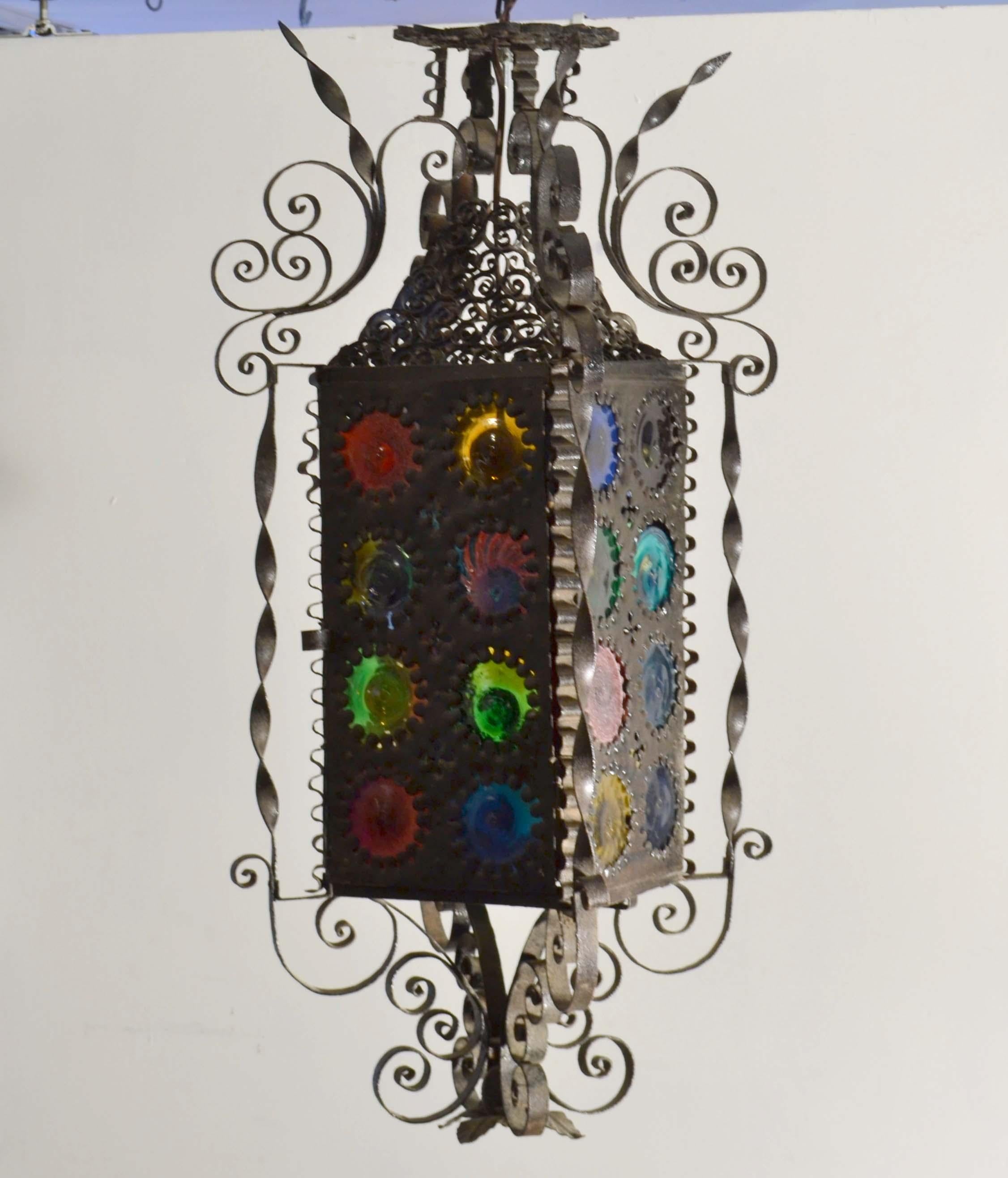 Lanterne italienne en fer forgé de la fin du 19e siècle avec ses vitres rondes multicolores. Chaque disque est unique, soufflé et coloré à la main, probablement originaire de l'île vénitienne de Murano. La balise est généralement placée dans un