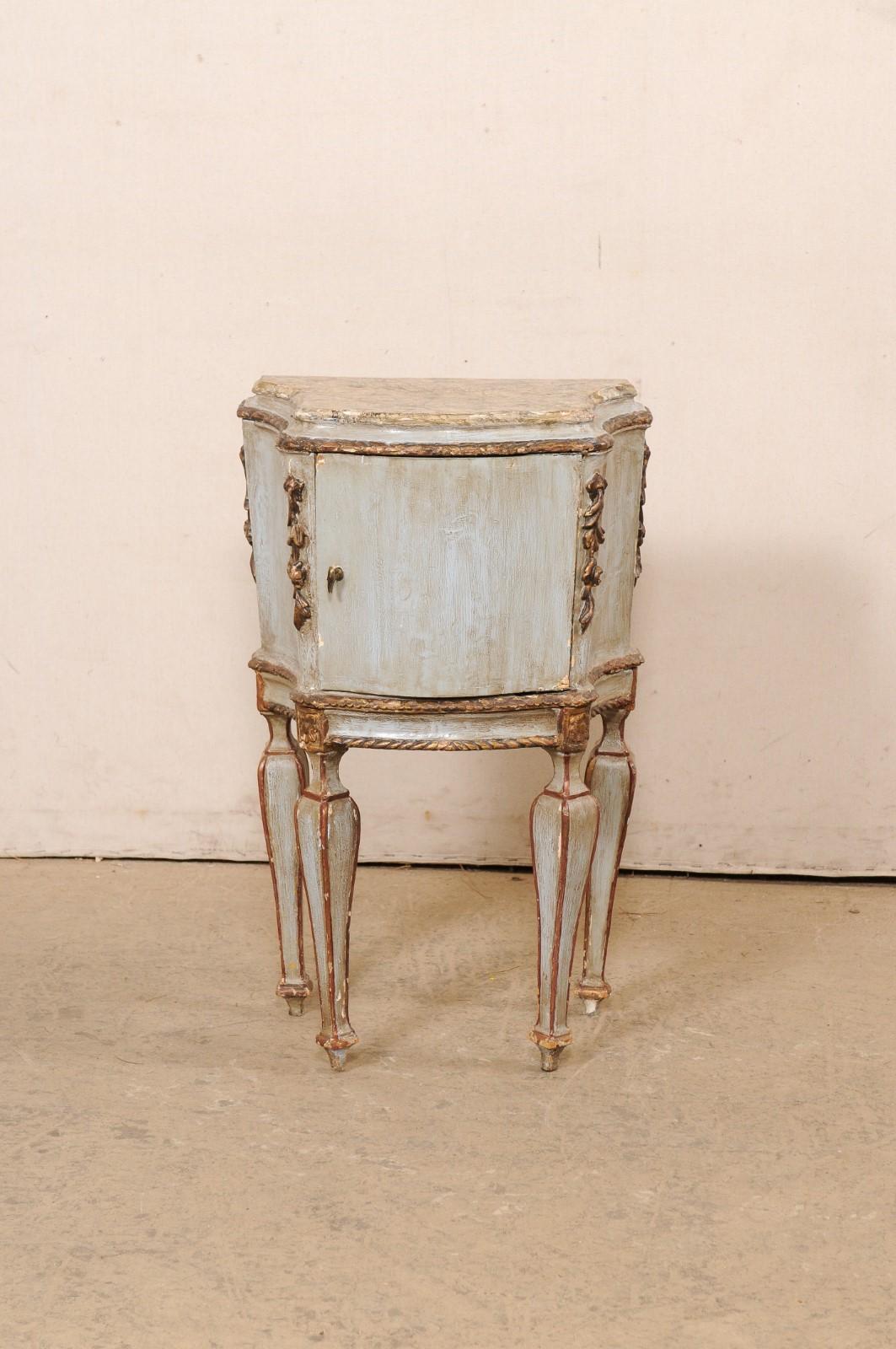 An Italian Venetian petite side chest, with faux marble top, from the turn of the 18th and 19th century. This antique small-sized commode has an artistically painted faux-marble top with a shapely bowed front, with convex sides that end in squared