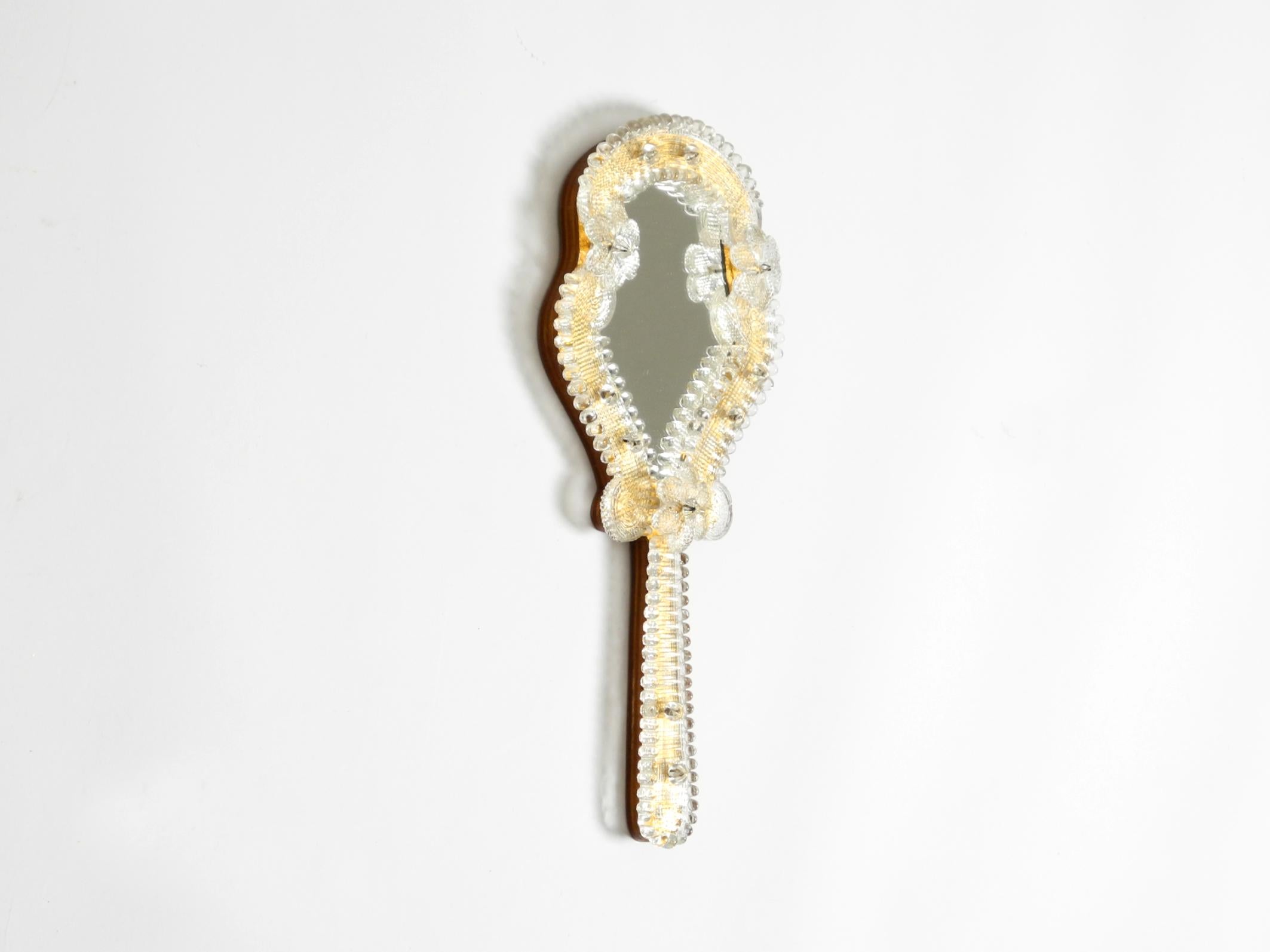Bellissimo specchio a mano o da parete in stile Mid-Century Modern veneziano con rosette in vetro di Murano. Prodotto in Italia. Gli elementi in vetro hanno la forma di fiori.
Uno specchio straordinariamente bello e ricco di dettagli.
Artigianato di