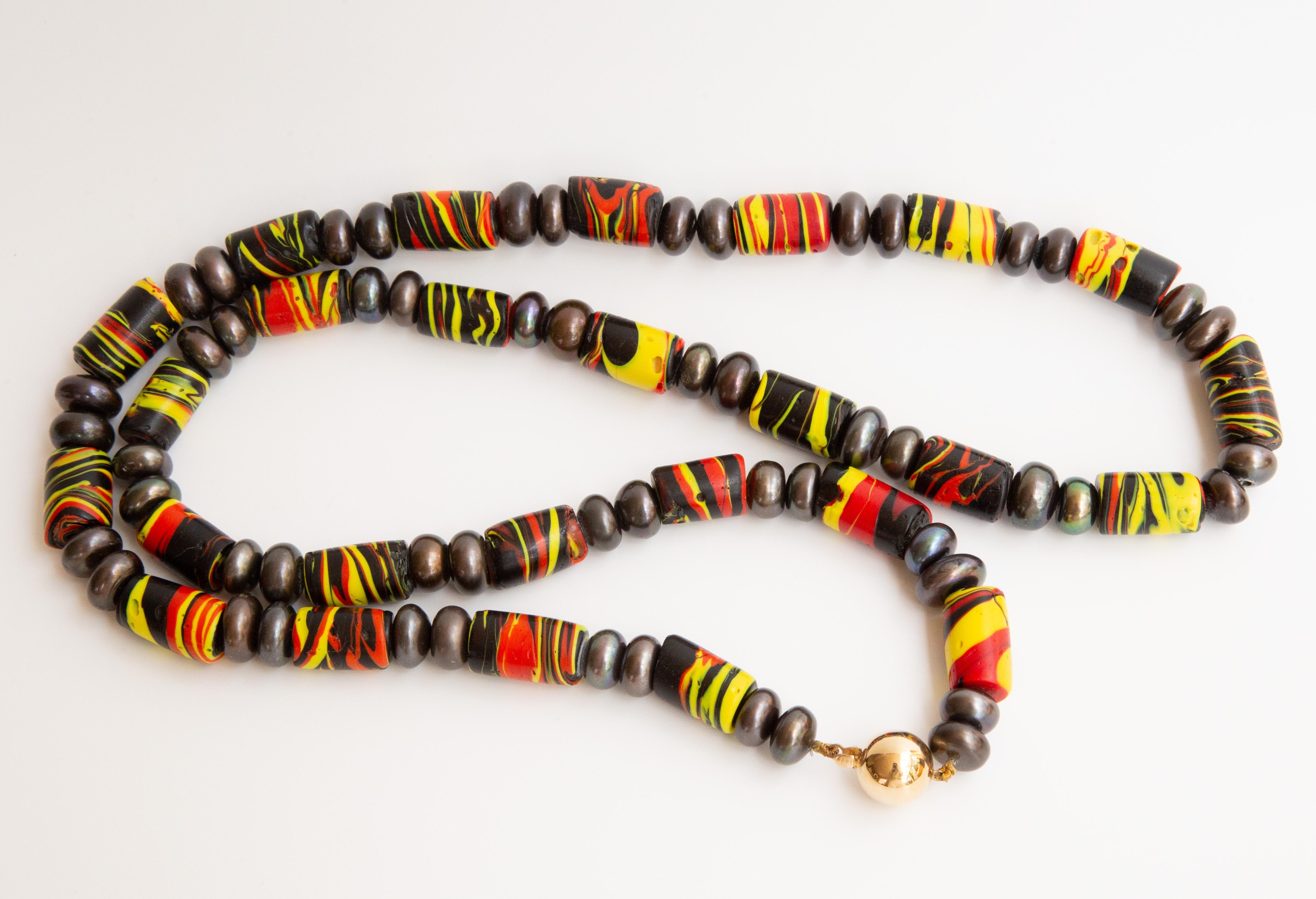 Collier moderne composé de perles de verre Millefiori vénitiennes anciennes et de perles en métal de couleur étain (en guise d'intercalaires). Le collier se ferme à l'aide d'un fermoir boule en or 14 carats brillant. Les perles en verre vénitien