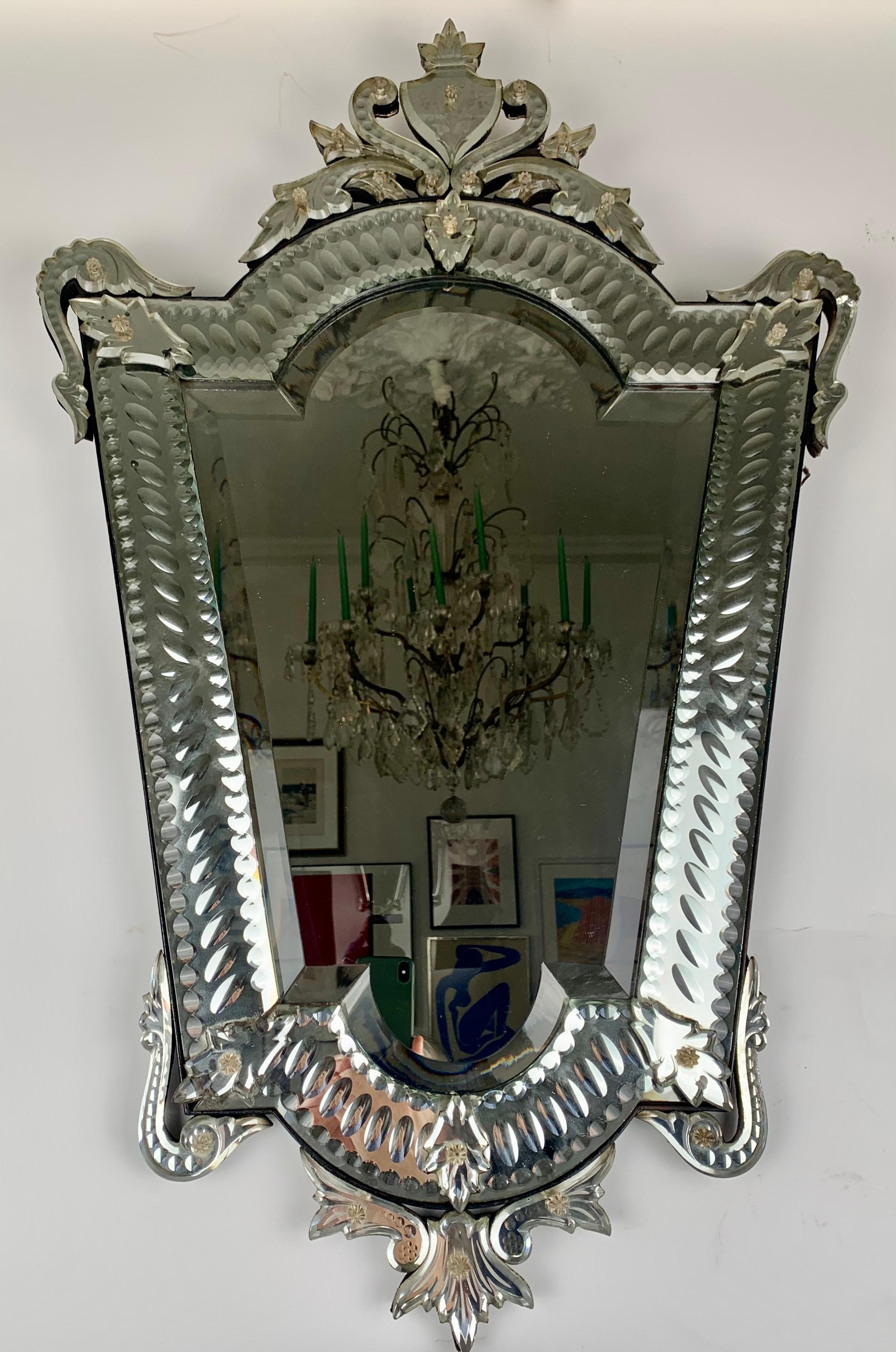 Venetian mirror in a trapeze shape with floral motifs.
Italy, circa 1930.