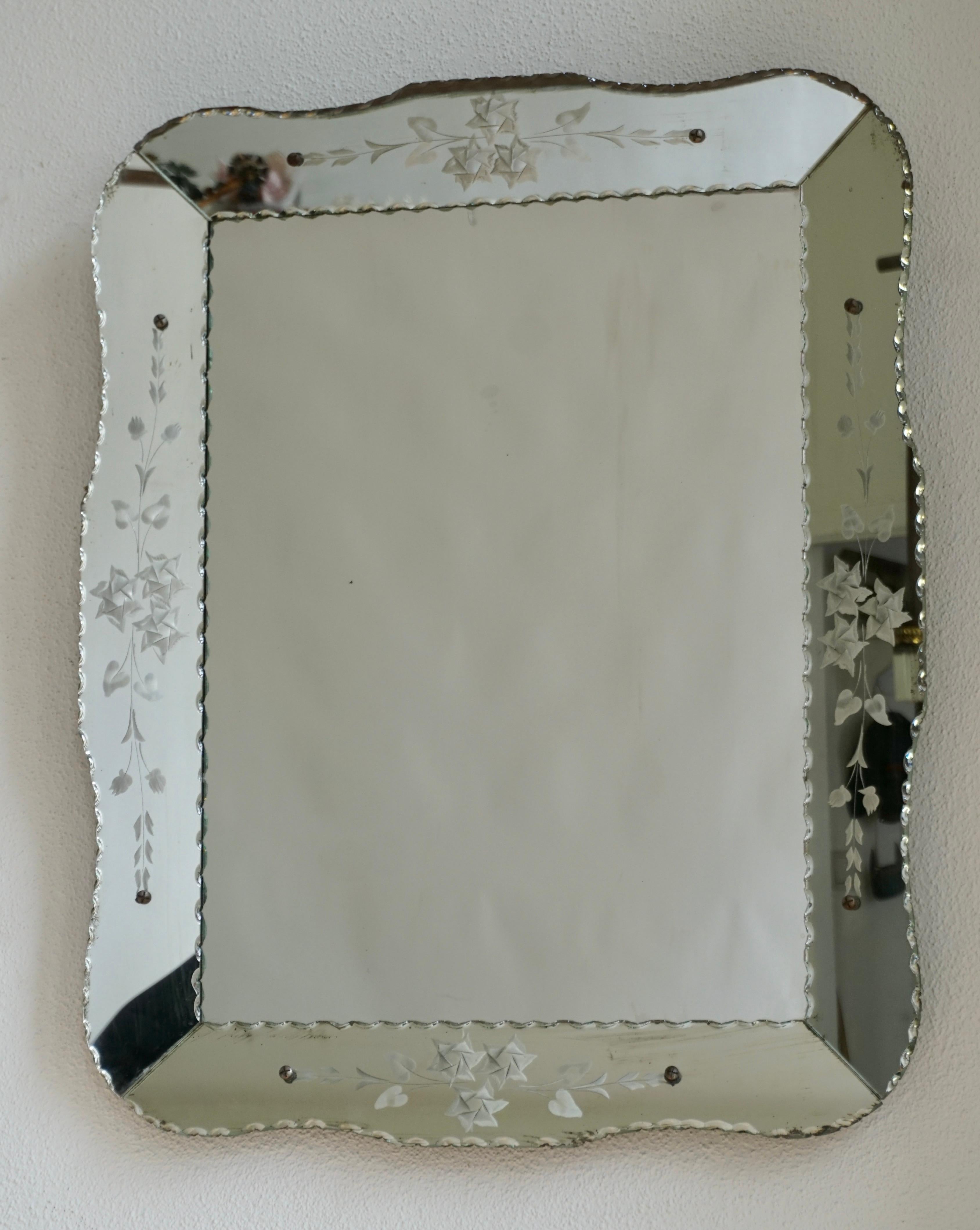 Miroir vénitien vintage gravé et biseauté. 
Ce miroir vénitien de forme inhabituelle a un périmètre biseauté. Miroir parfait pour une salle d'eau ou un dressing.