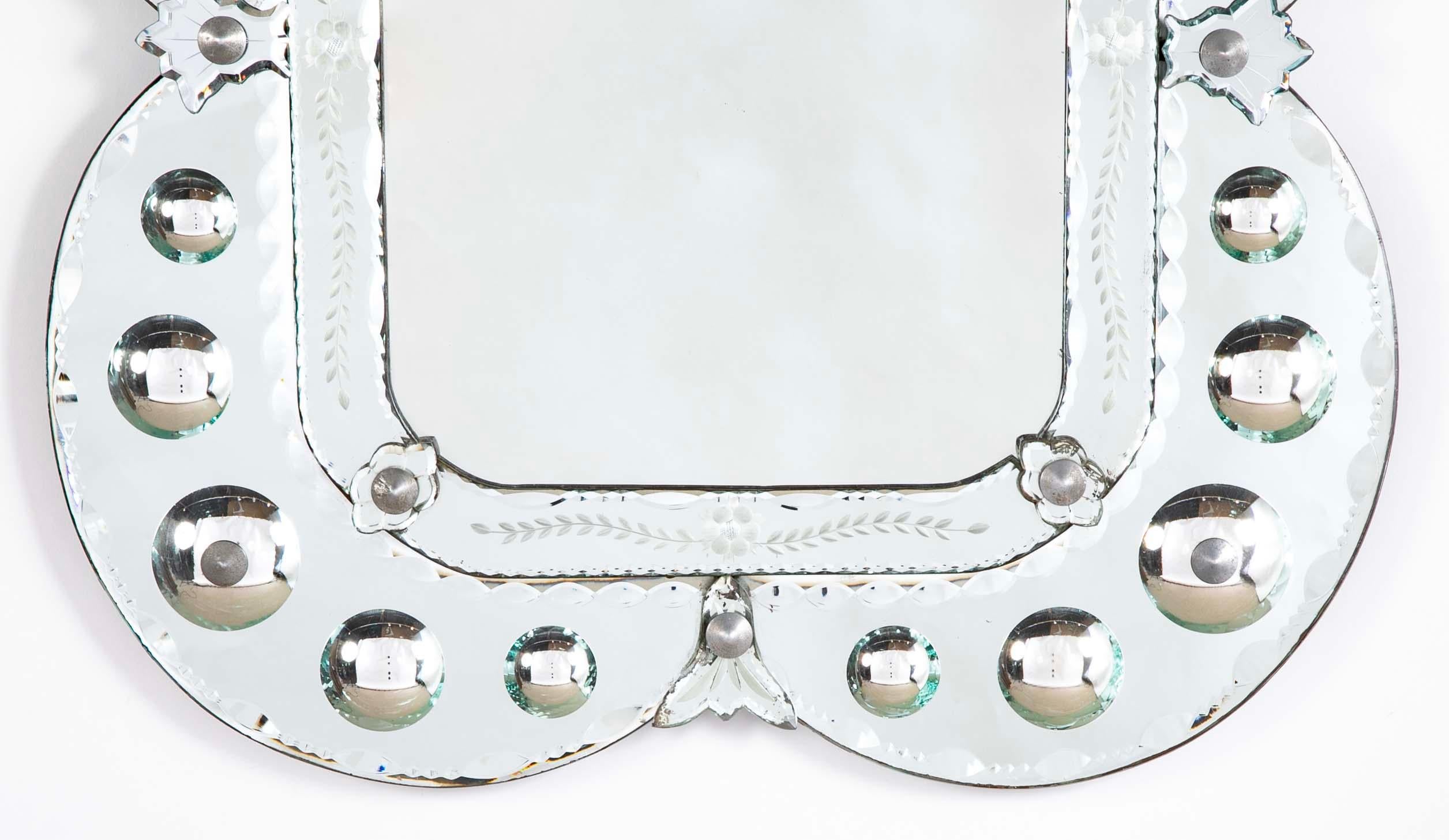 Specchio veneziano in vetro acidato con cornice a specchio convessa. Di forma insolita e molto accattivante, lo specchio interno è incorniciato da un vetro acidato a disegni floreali, con un meraviglioso quatrefoil  La cornice è punteggiata da tante