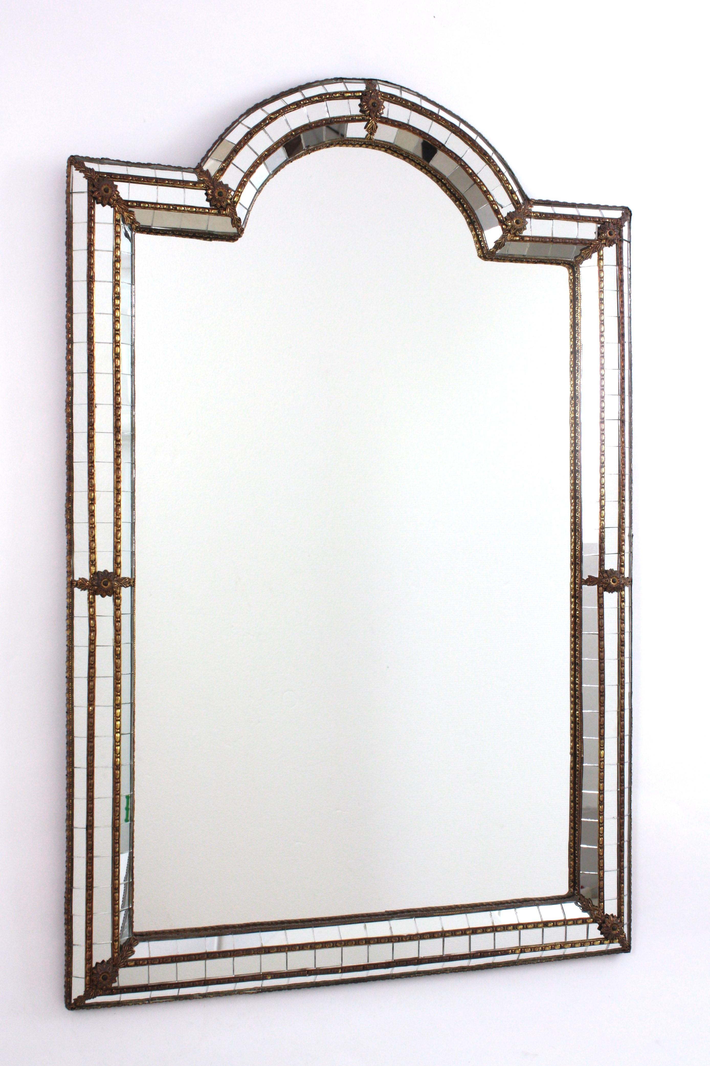 Miroir en arc de cercle de style vénitien avec accents en métal doré, Espagne, années 1960
Ce miroir glamour est doté d'un cadre à trois couches en laiton. Le cadre comporte trois couches de mosaïque de miroirs composée de petits morceaux de miroirs