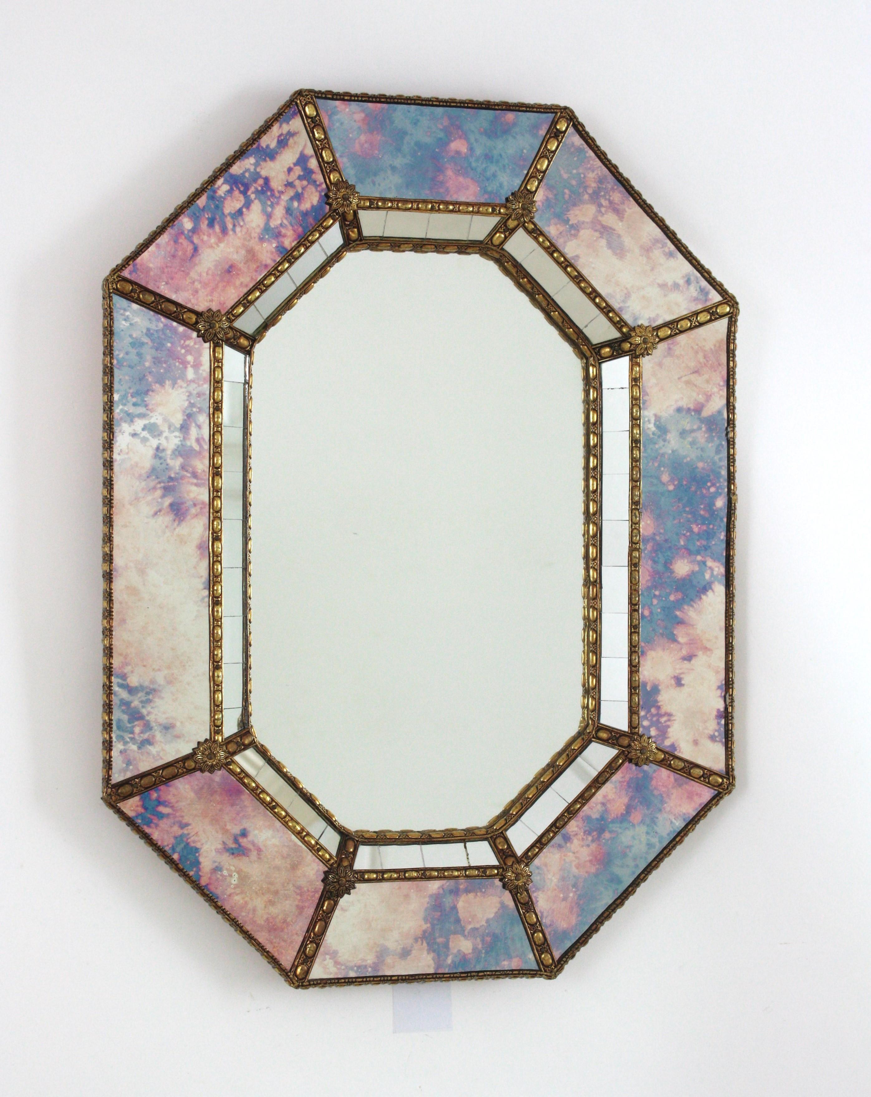 Cool Venetian style Hollywood Regency octagonal mirror with iridiscent and mirror glass panels. Spain, 1960s
This glamorous wall mirrors features a double layered mirror frame made of brass. Octagonal form with frame with two layers of decorative