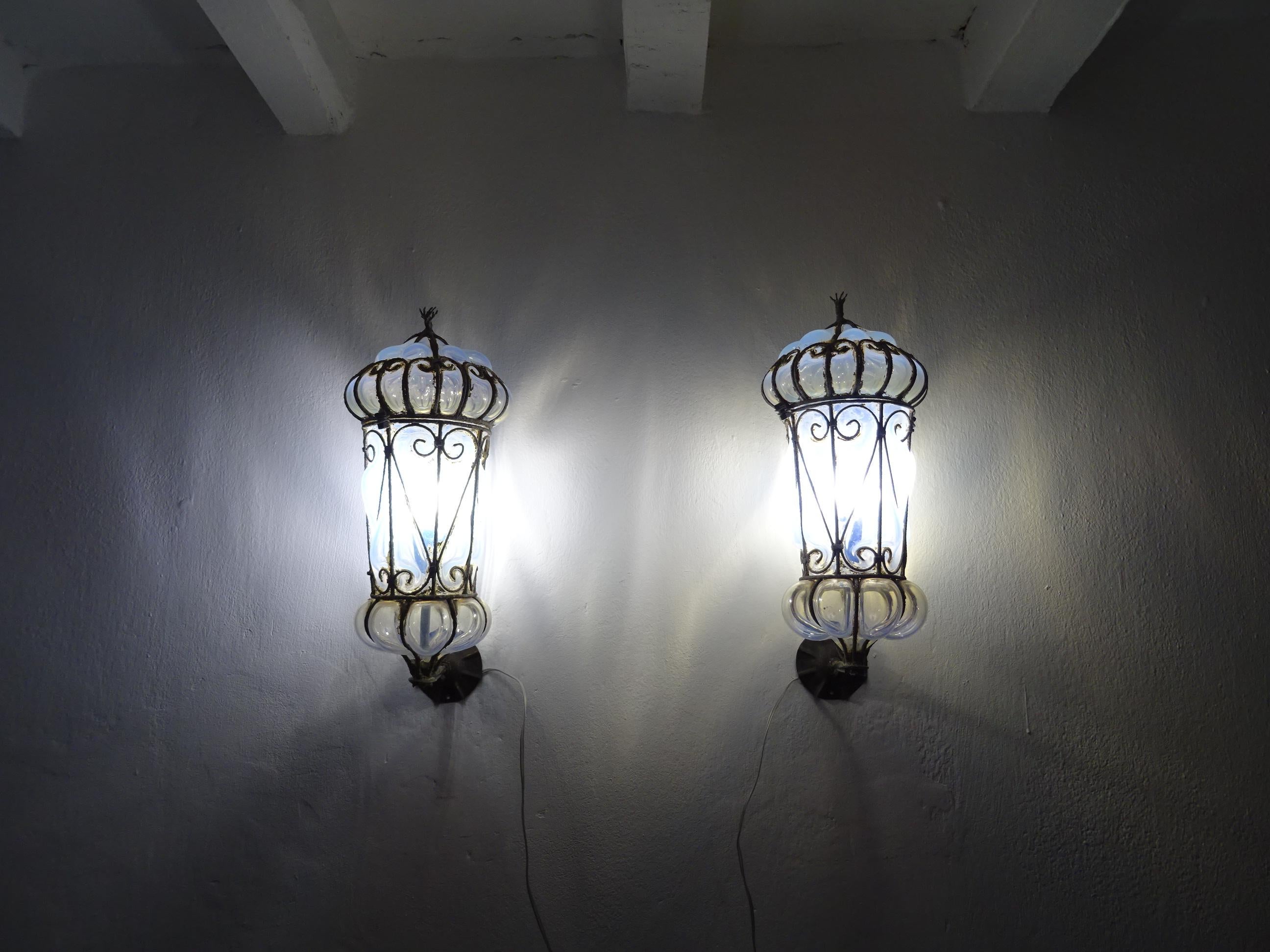 Housing one light each. Will be rewired with certified US UL sockets for the USA and appropriate sockets for all other countries and ready to hang. Blown Murano opaline glass lanterns or sconces with scroll metal. Free priority UPS shipping from