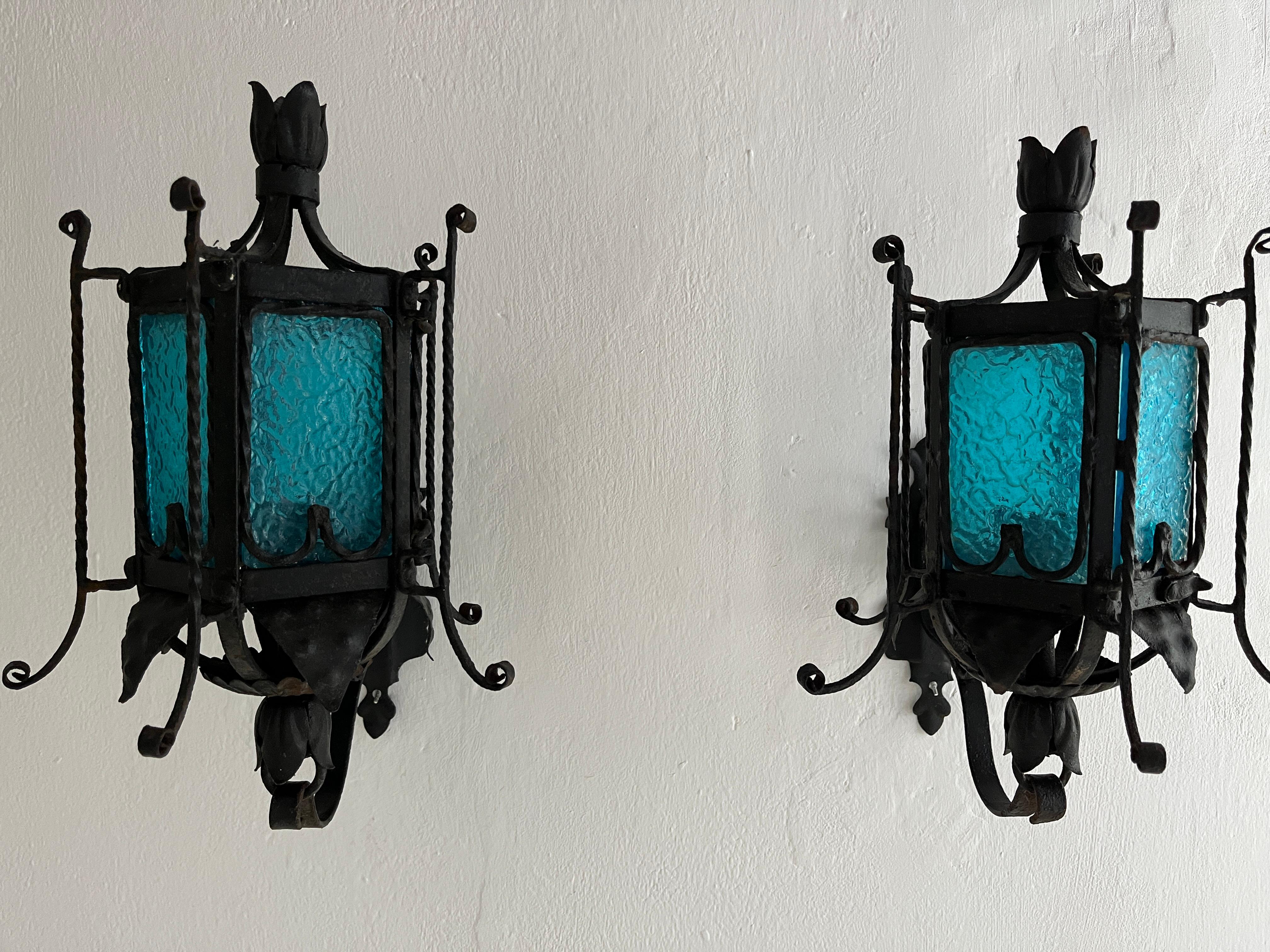 Housing one light each. Will be rewired with certified US UL sockets for the USA and appropriate sockets for all other countries and ready to hang. Rare aqua blue Murano glass lanterns or sconces with detailed wrought iron. All panes are in great
