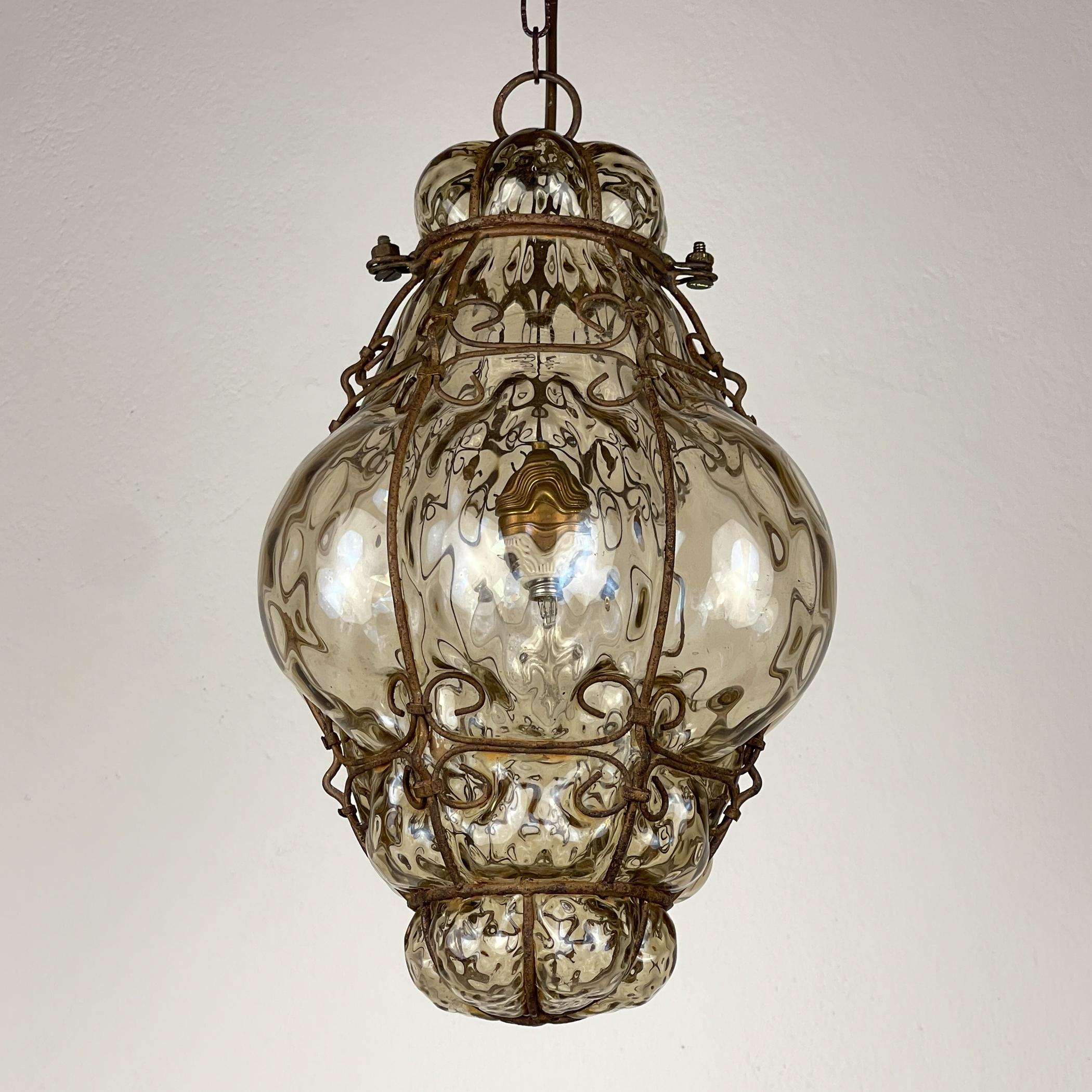 

Original Murano glass Venetian lantern made in Italy in the 1940s. The glass is blown within a metal frame that characterizes the shapes.

Vintage pendant lamp is in good vintage condition. The metal has a nature patina.

Dimensions:
Width: 20 cm