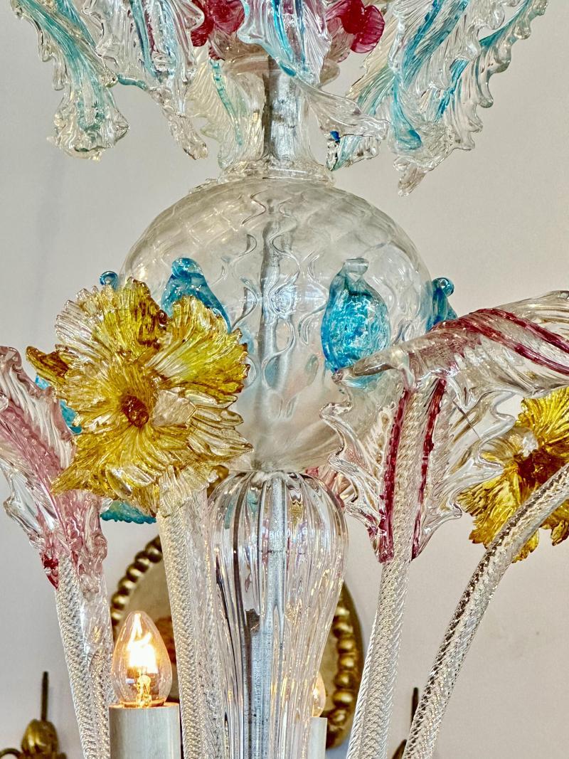 The blown glass standard of ball form resting on a glass baluster issuing eight scrolling arms holding candle cups and lights above a cut glass dish
