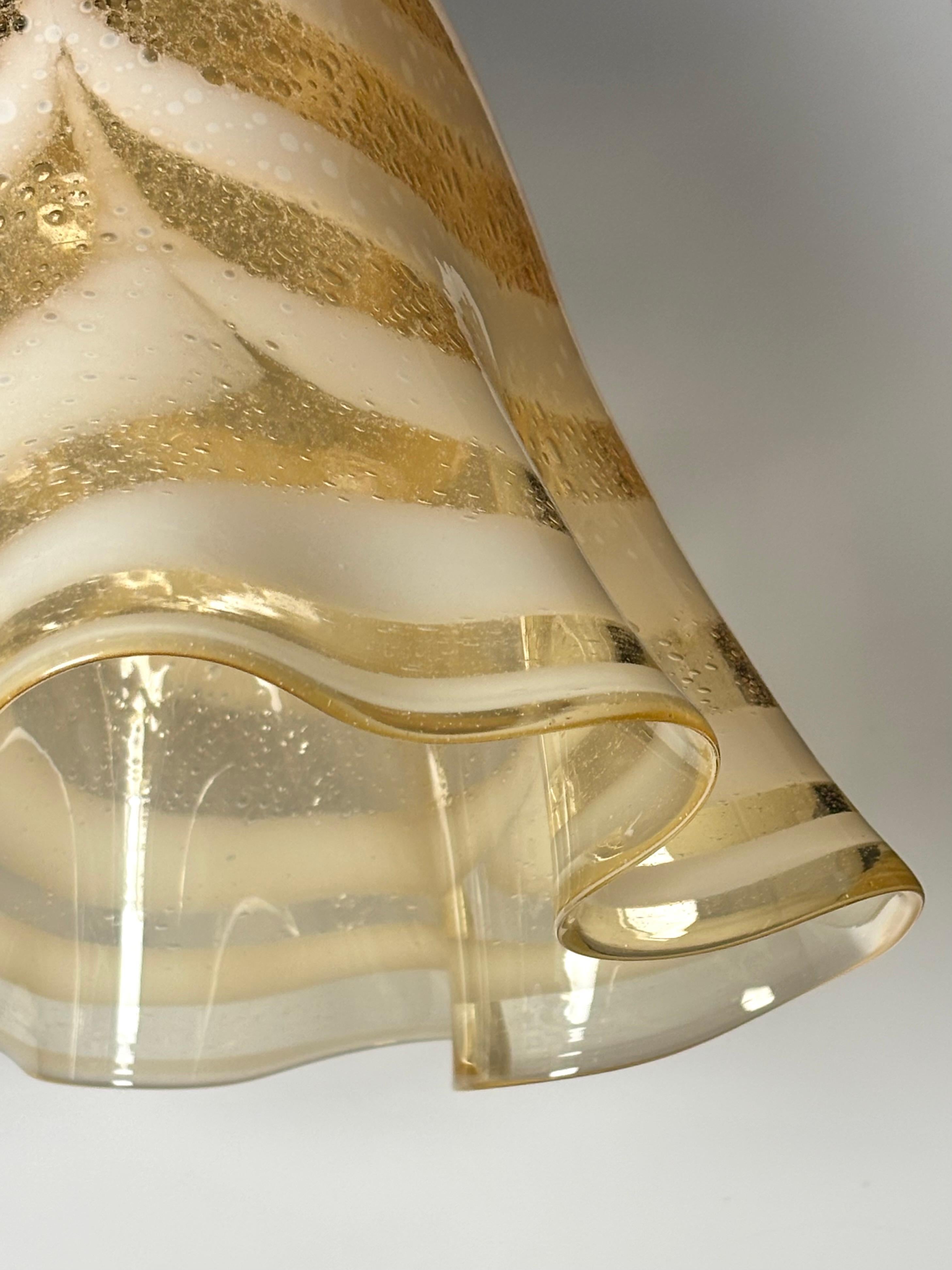 Impressionnant plafonnier en verre d'art rayé de Murano des années 1970, attribué à AV Mazzega. La forme est connue sous le nom de Fazzoletto en raison de sa ressemblance avec un grand mouchoir qui semble avoir été jeté au-dessus d'une ampoule avec