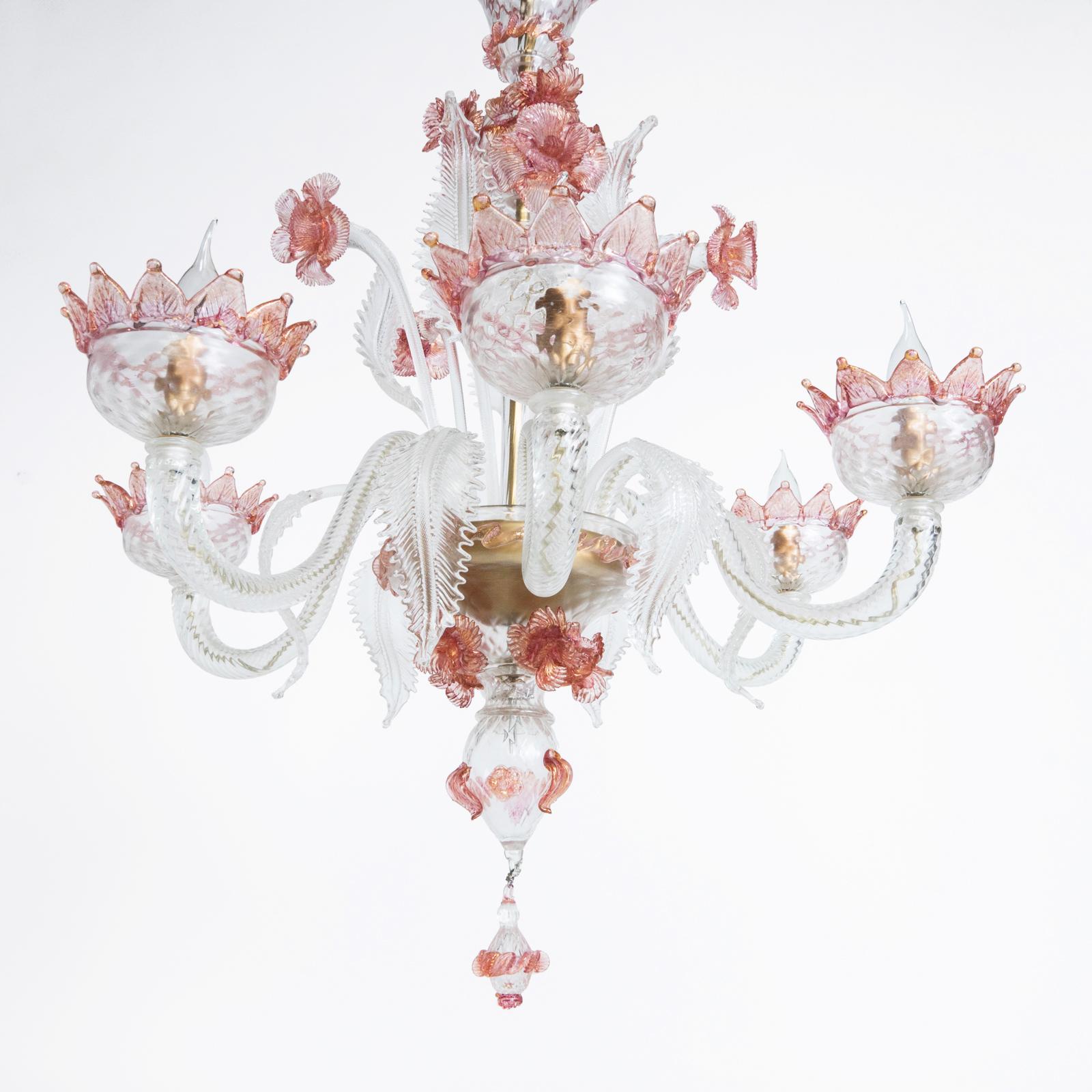 Scopri questo delizioso lampadario in vetro di Murano in vetro bianco con dettagli rosa e oro, una vera meraviglia di artigianato. Con sei luci radianti, non solo illumina il tuo spazio ma lo infonde anche con un delizioso mix di giocosità e