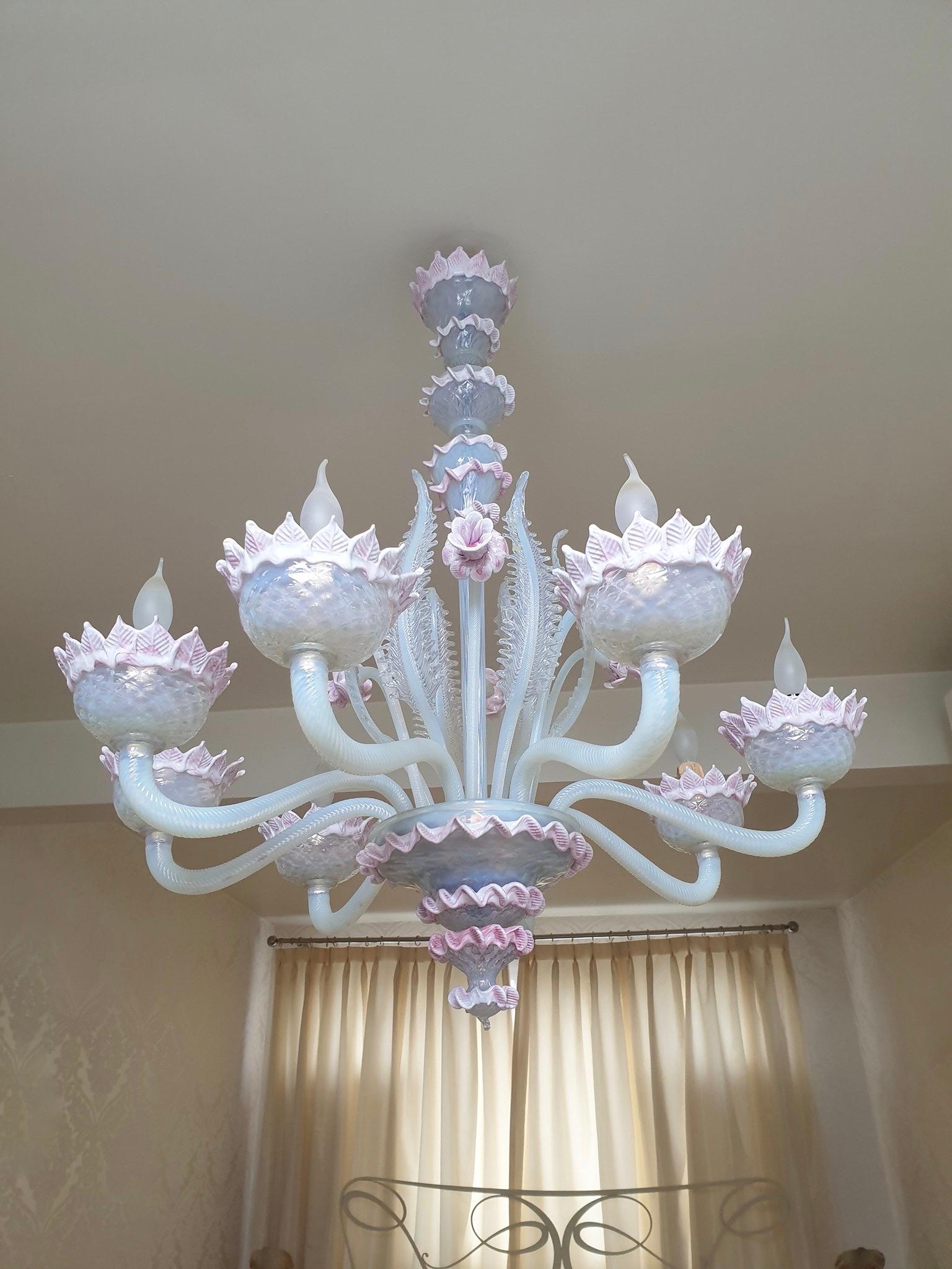 Venetian blown glass chandelier, crafted in Murano Italy, in the mid-20th century. A timeless Murano circular chandelier with an elegant structure finely decorated with eight curved arms ending with upwards corolla shaped bobeiges.
A central pillar