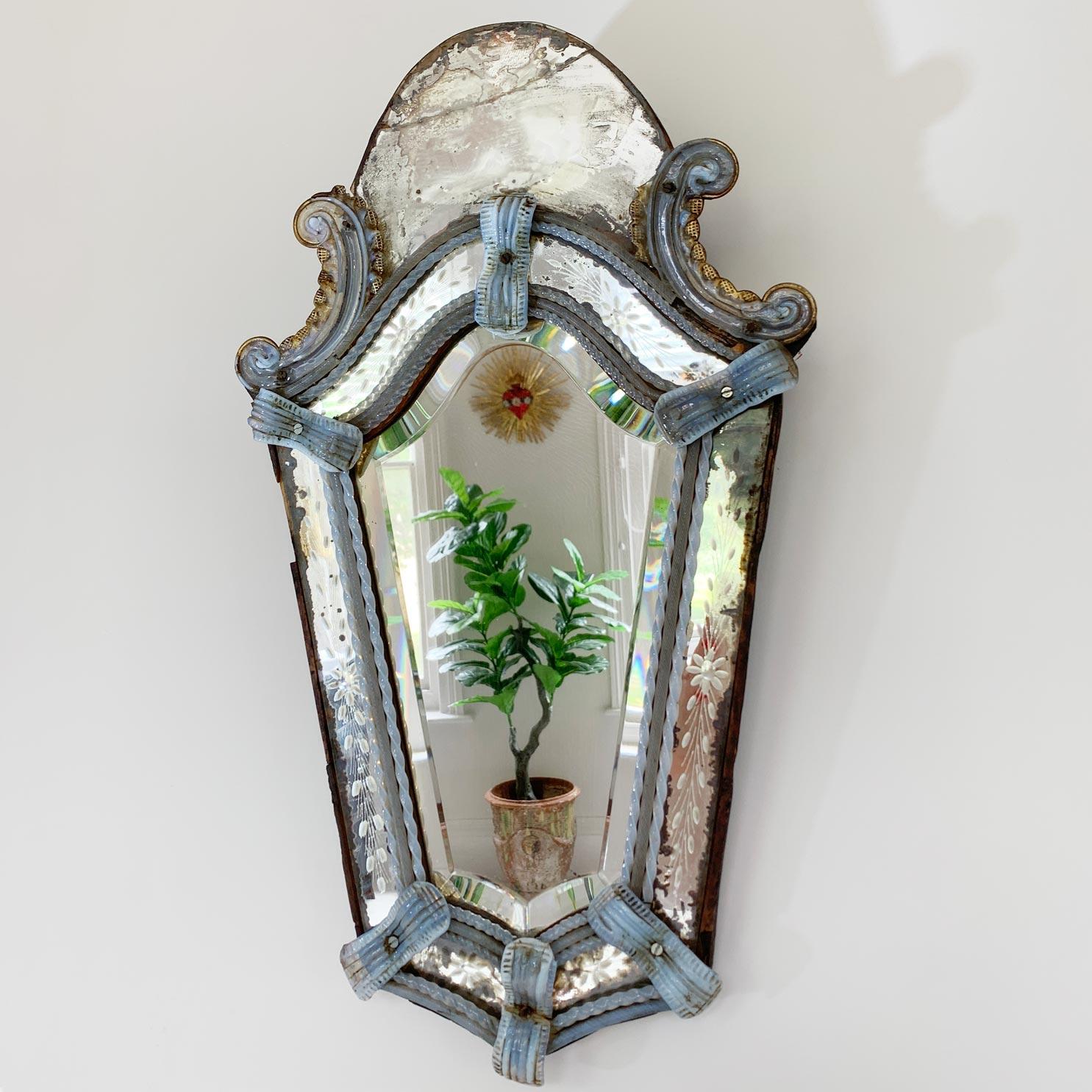 An achingly pretty 19th century Venetian murano glass wall mirror, with etched griffon holding St.Mark's gospel under it's front paw. The opaque light blue glass twists and bows are exquisitely made, the flower or possibly sun and wheat etched