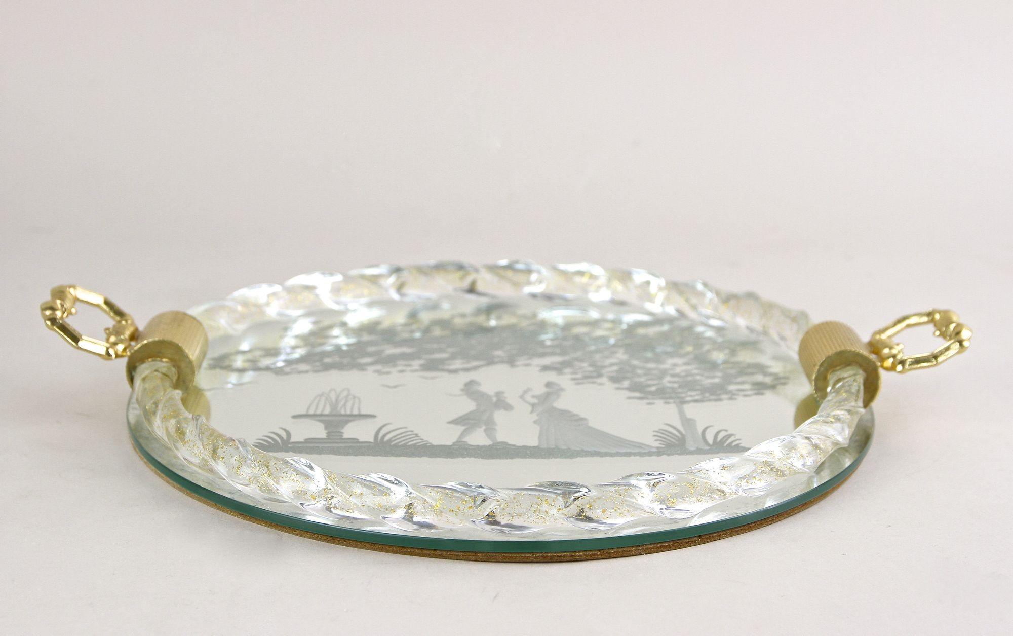 Preciosa bandeja/plato de cristal espejado de Murano de mediados de siglo con asas doradas de los años 60 en Italia. Con un diseño artístico, esta hermosa bandeja con espejo de Murano impresiona con una escena grabada/grabada de estilo rococó que