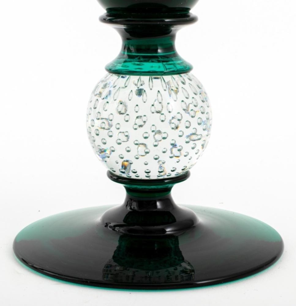 Venetian Murano peacock green and colorless seeded glass covered jars, a pair, each with seeded clear glass finial above green circular lids, the flaring green glass body above a seeded colorless glass balls on green circular feet.
0.5