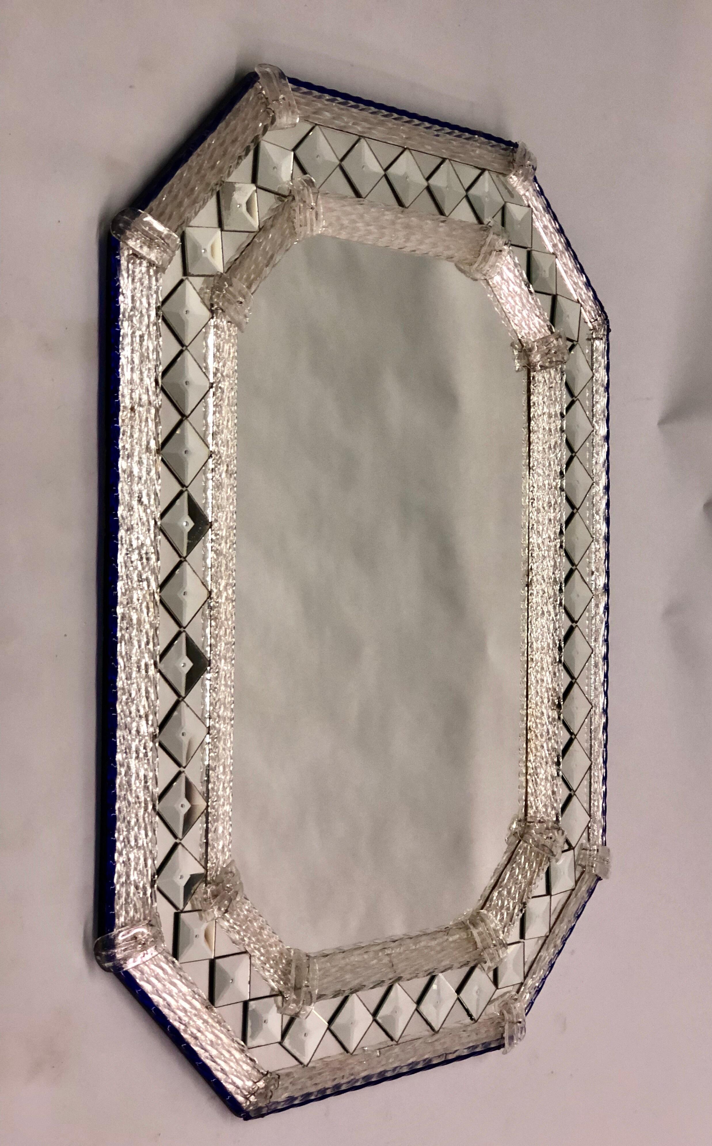 Elegant, timeless, Venetian / Murano Mid-Century Modern neoclassical mirror with a blue ribbon glass outer border and 2 clear ribbon glass internal borders surrounding the central mirror plate. Diamond shaped mirrors are inset between the 2 clear