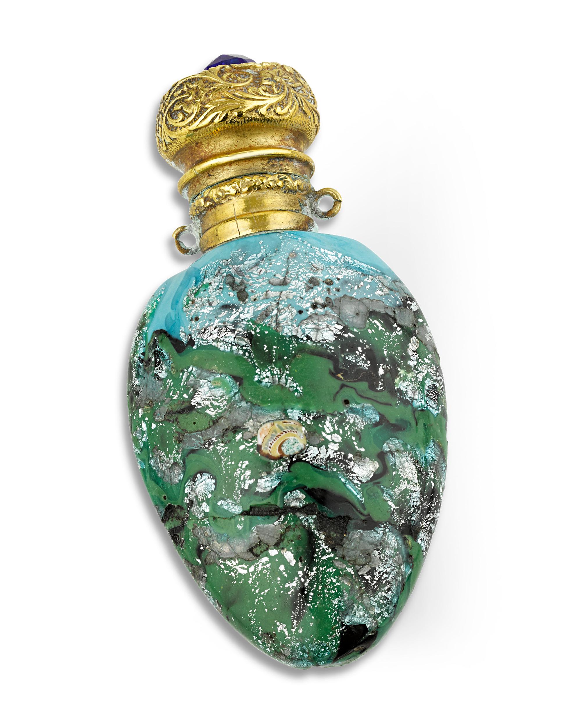 Colorful segments of murrine glass dot the surface of this marbled glass perfume bottle. Swirls of blues, greens and silvers display the skill of the famed Venetian glass masters.