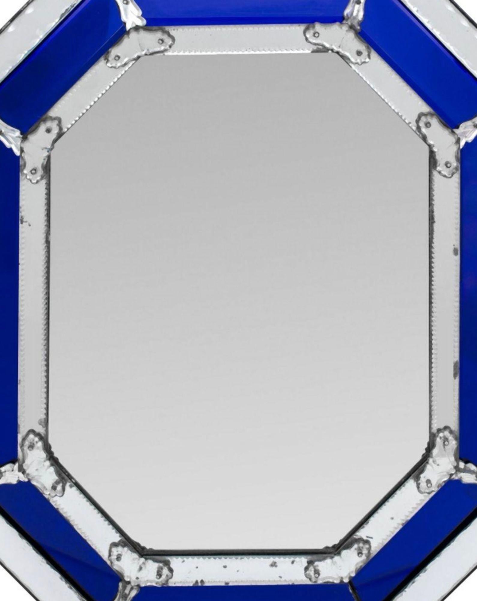 Stunning Venetian octagonal mirror, made in Italy during the 1960's, features a beveled mirror plate at its center, encased in a colorful frame of cobalt blue Murano glass panels. The rich hue of the Murano glass complements the beveled mirror plate