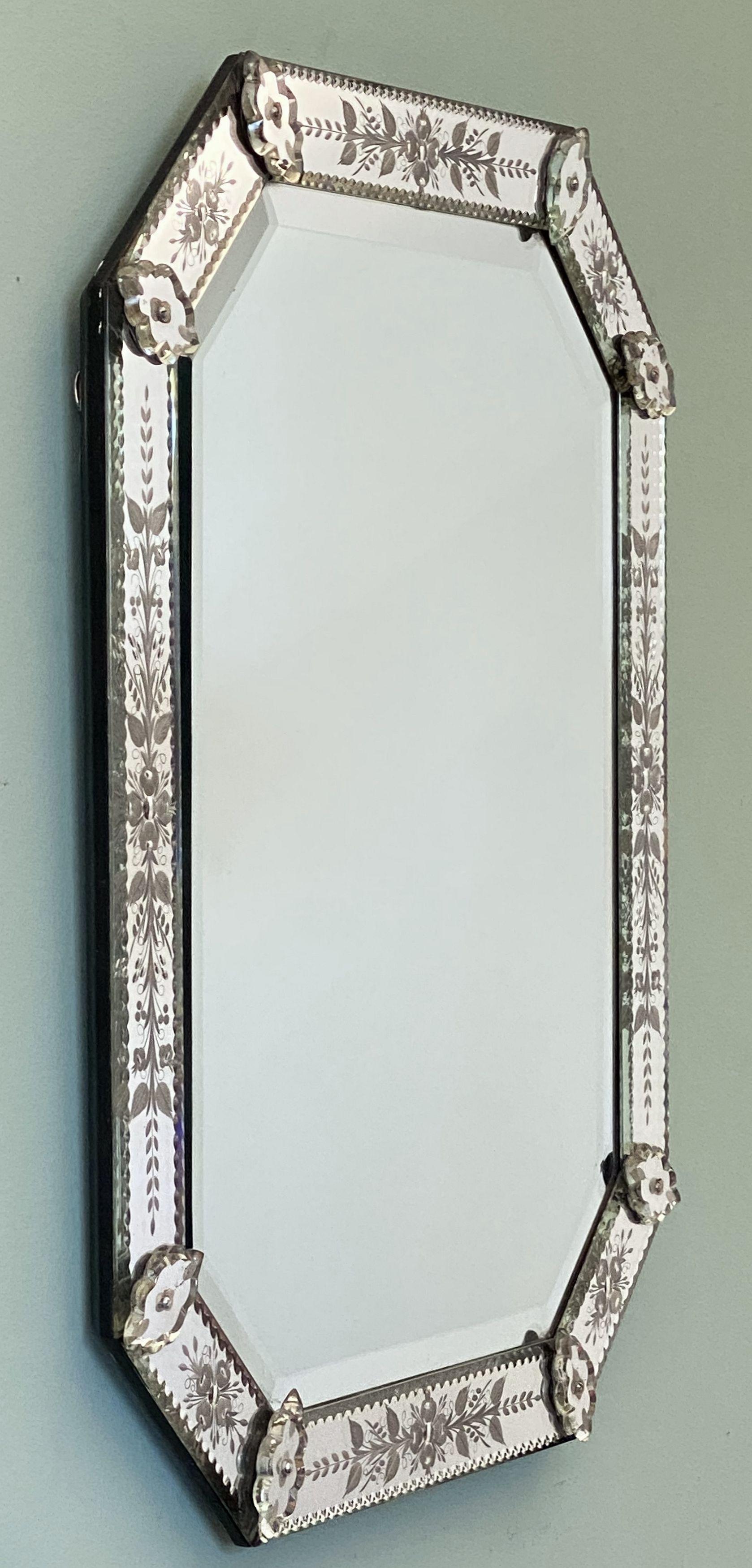 A fine Venetian octagonal wall mirror from Italy, featuring an eight-sided etched mirrored glass frame with an elegant foliate design, with eight decorative mirrored glass cartouches, surrounding a beveled mirror in the center.

Dimensions are H