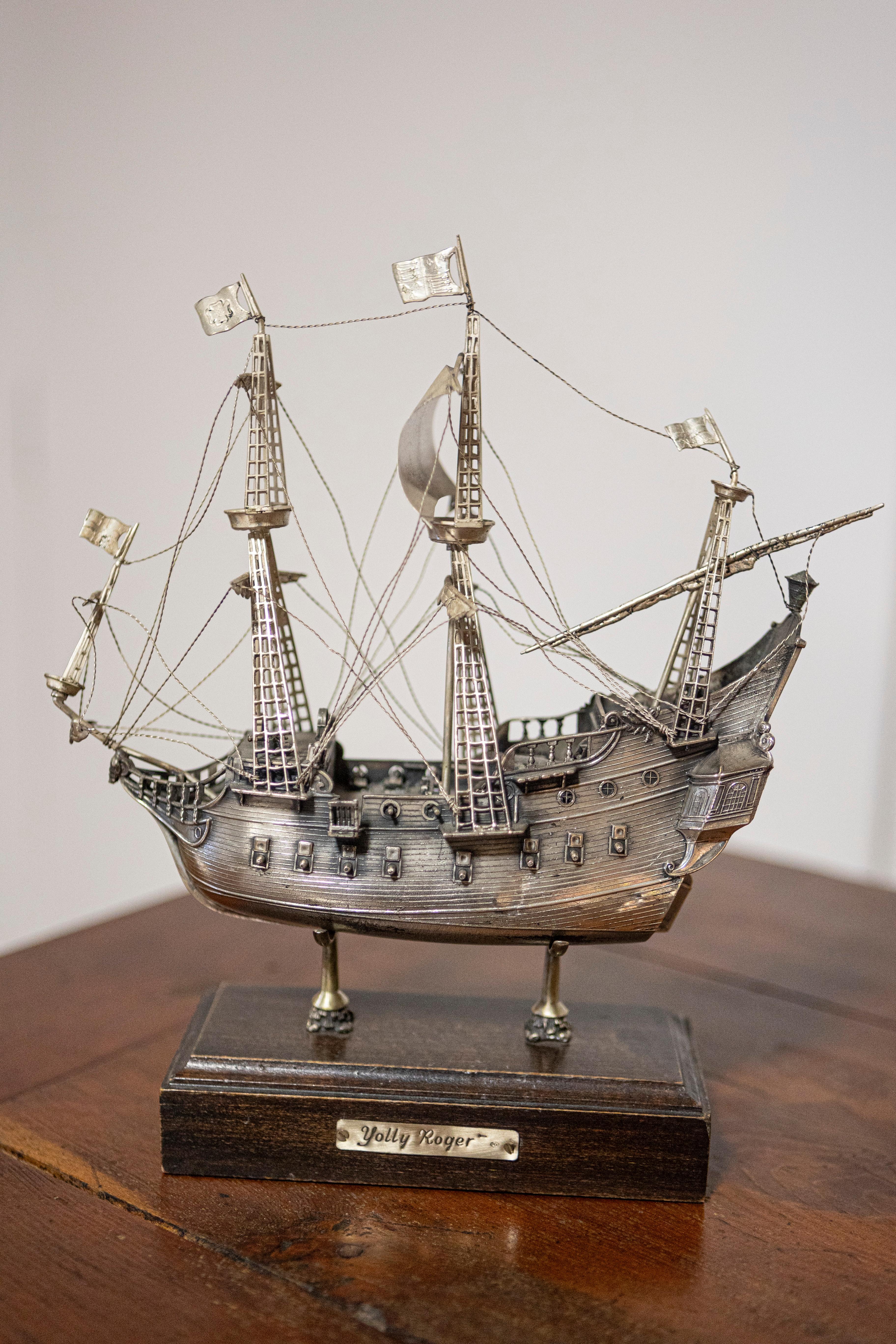 A Venetian Jolly Roger pirate model ship from the 20th century made from pewter alloy and mounted on a wooden base. This captivating Venetian Jolly Roger pirate model ship from the 20th century is a testament to meticulous craftsmanship and